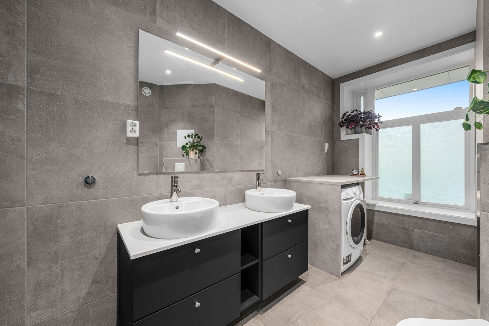 Praktisk innredning med benkeplate og plass til både vaskemaskin og tørketrommel. Vaskemaskin medfølger salget Galleribilde