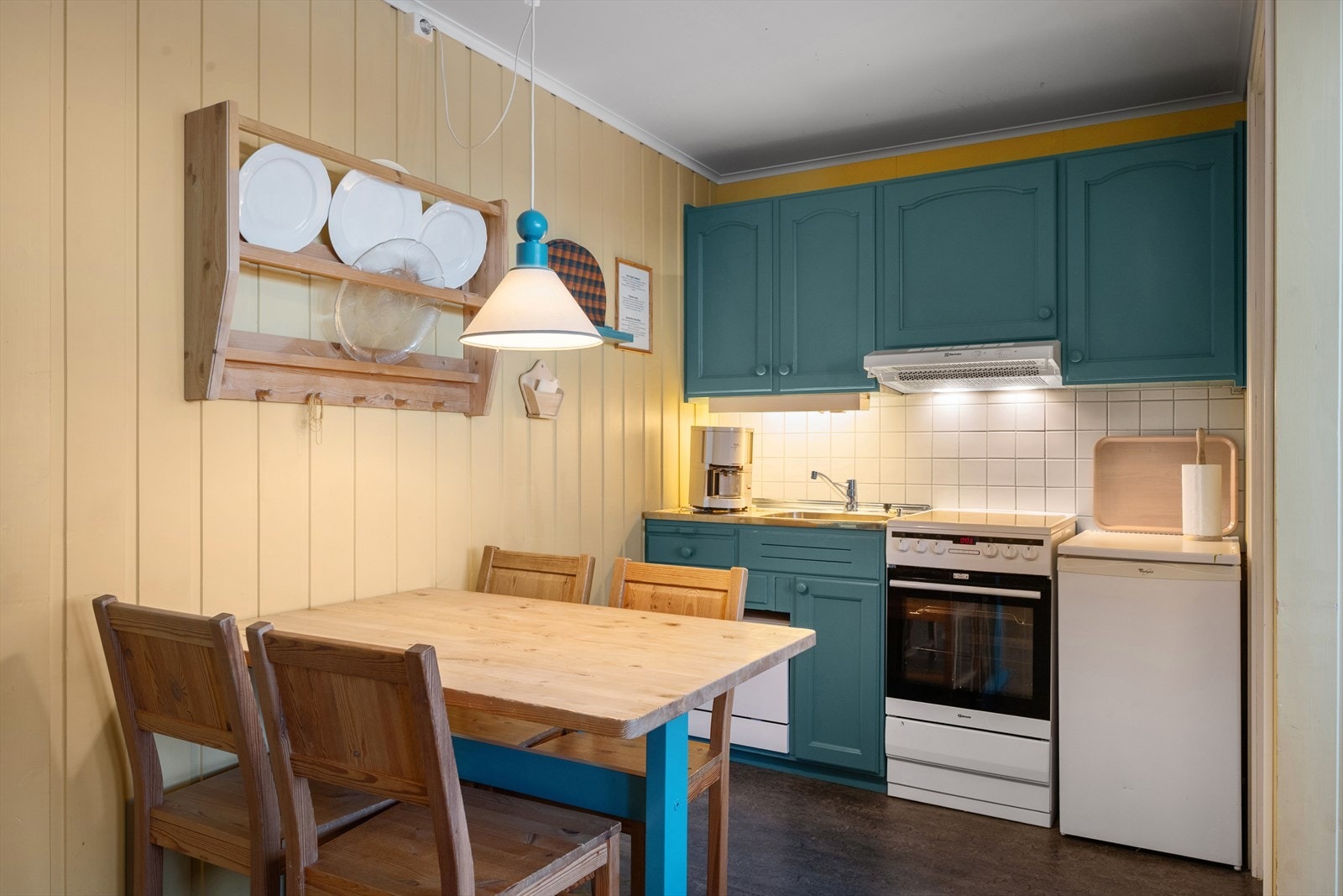 Kjøkkenet er utstyrt med komfyr, kjøleskap og benkoppvaskmaskin. Galleribilde