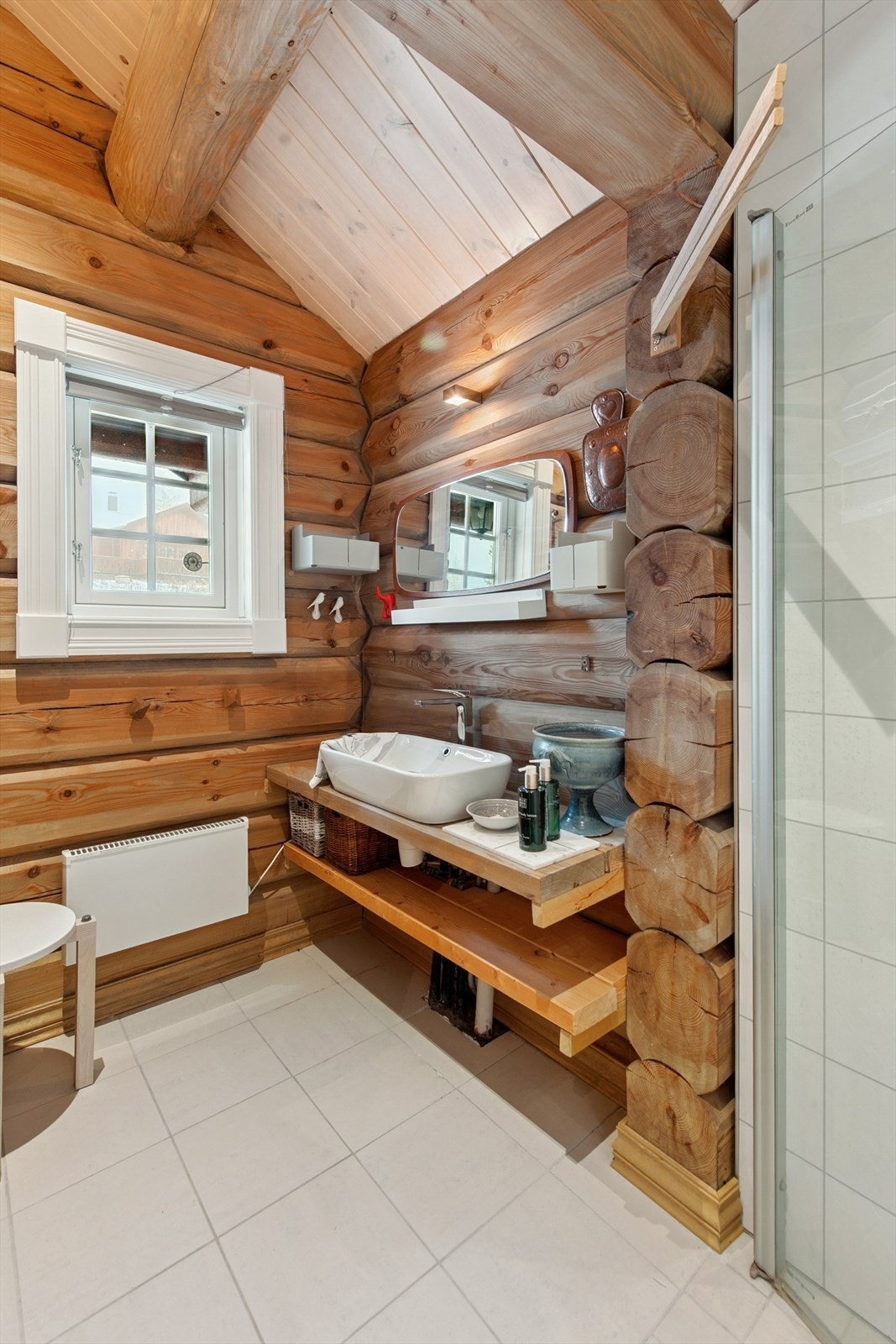 Vegger kledd med en kombinasjon av våtromsplater, tømmer og glassbyggerstein. Galleribilde