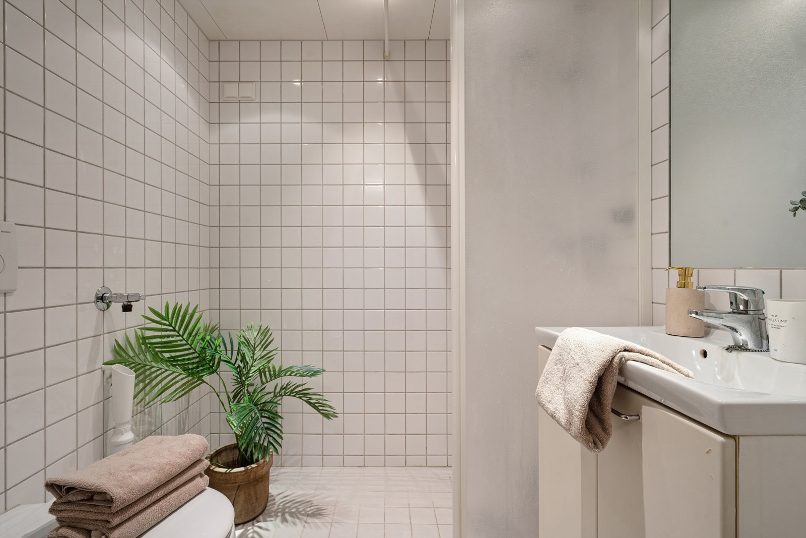 Bad/wc består av vegghengt wc, servant m/underskap, innfliset speil m/overlys, åpen dusj m/glassvegg mot innredning og forheng, samt opplegg for
vaskemaskin. Galleribilde