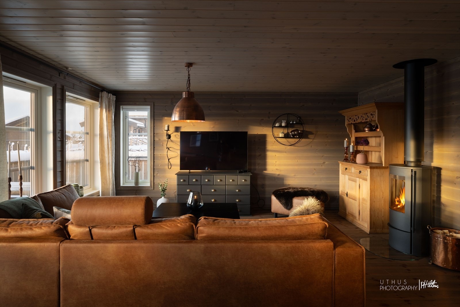 Hyggelig tv-krok med vedovn som sprer varme og atmosfære Galleribilde