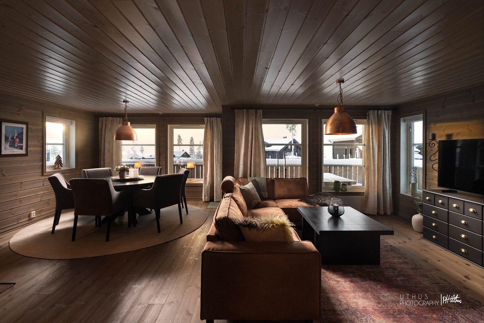 Romslig oppholdsrom med naturlige soneinndelinger og store vindusflater som gir rikelig med lysinnslipp Galleribilde