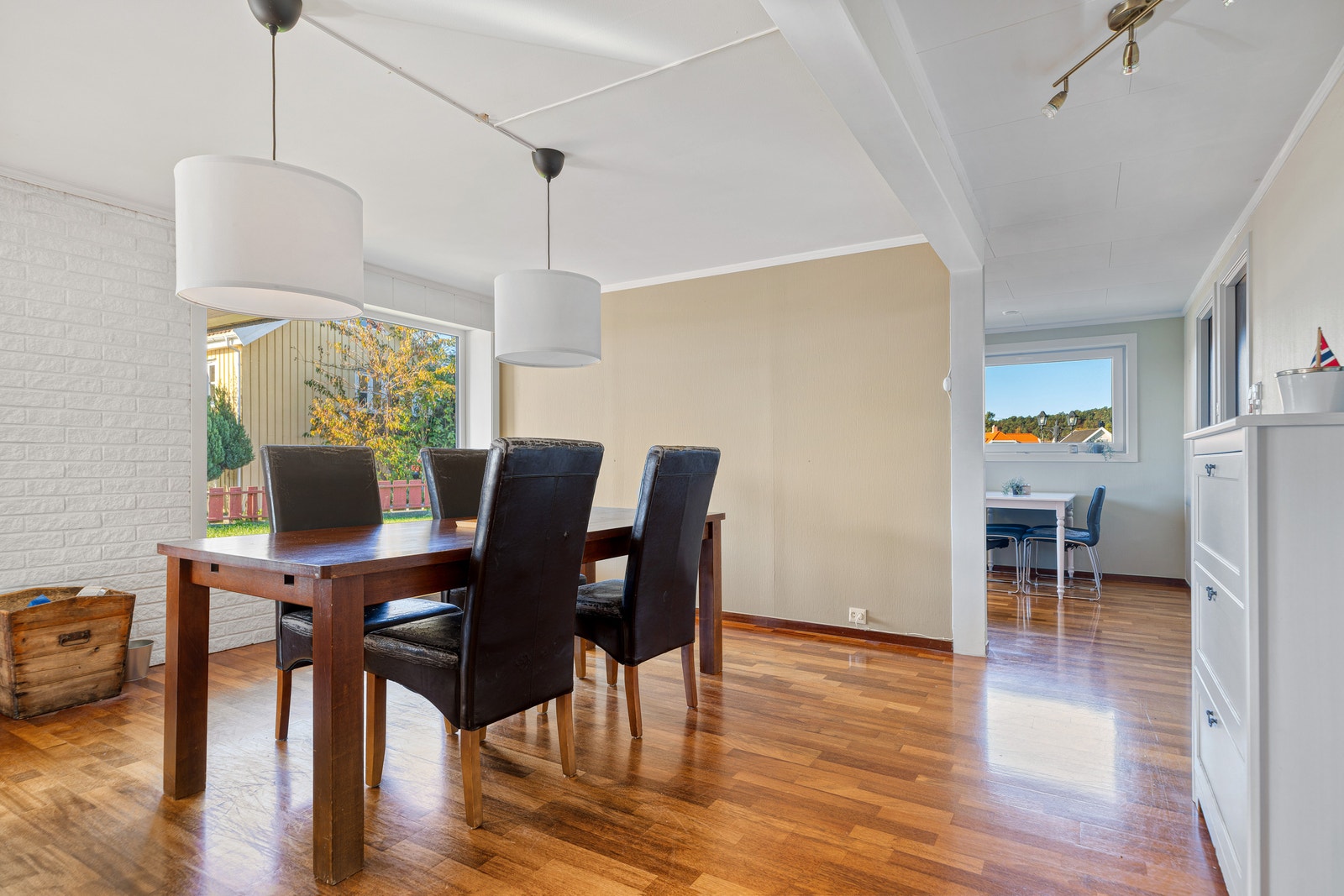 Spiseplass med to pendellamper og utsyn mot ekstra sitteplass ved vinduet. Galleribilde
