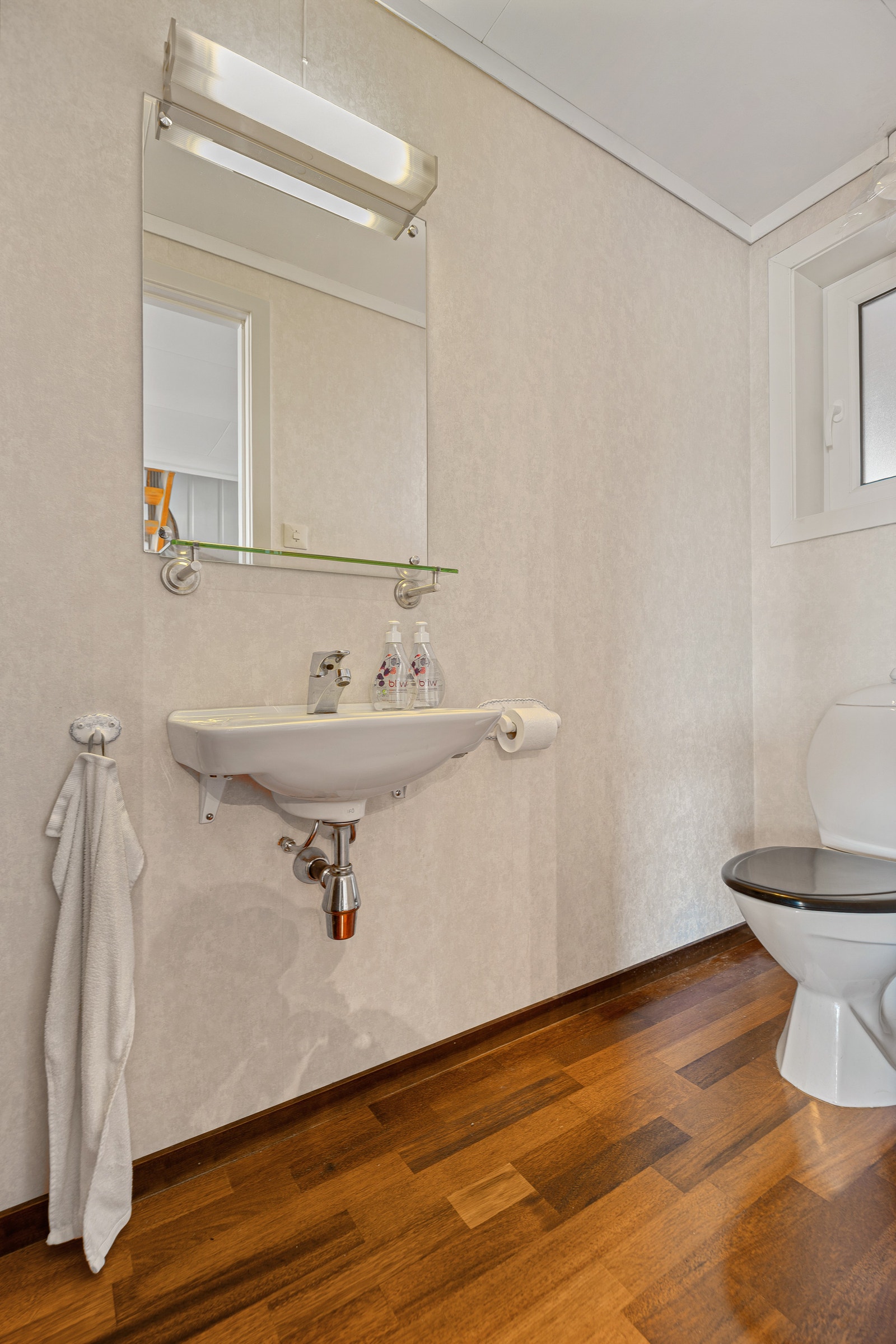 Toalettrom med vegghengt speil, servant og wc. Galleribilde