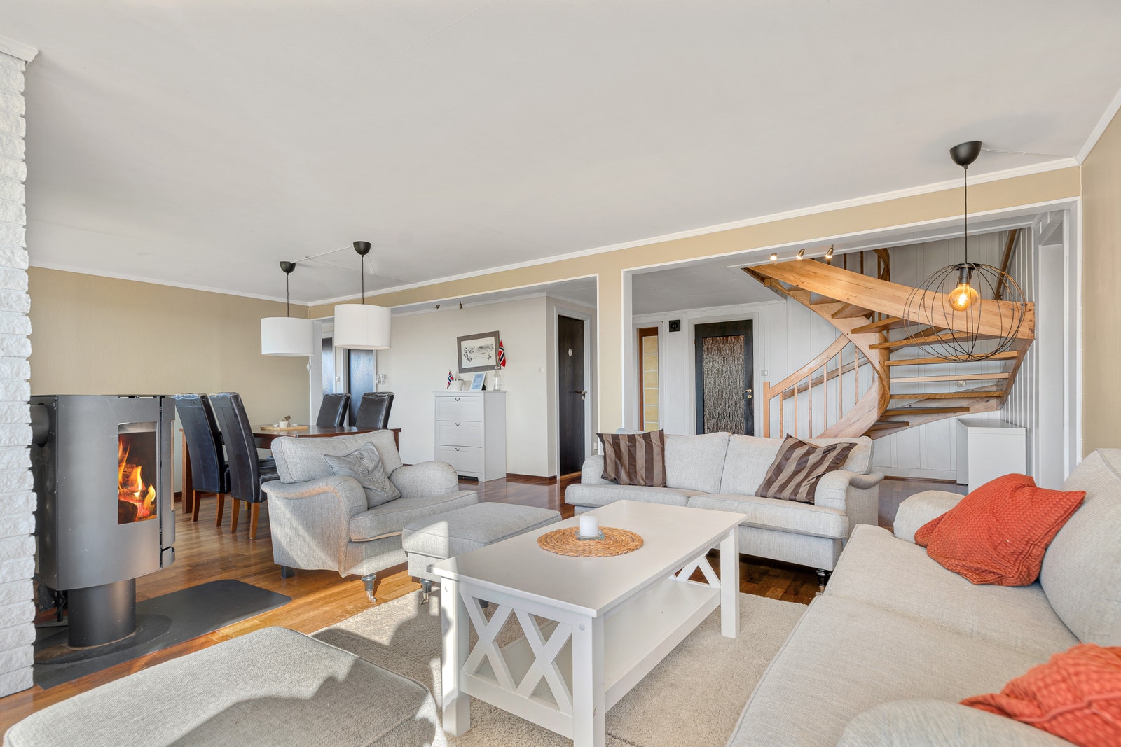 Stue med vinkeltrapp, sofagrupper og vedfyrt ovn. Galleribilde