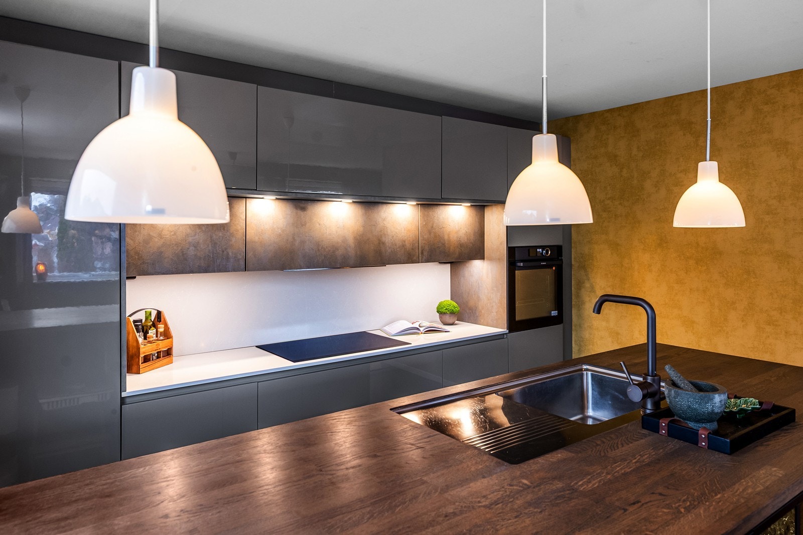 God arbeidsbelysning over benkeplaten og nedfelte stikkontakter i kjøkkenøya. Galleribilde