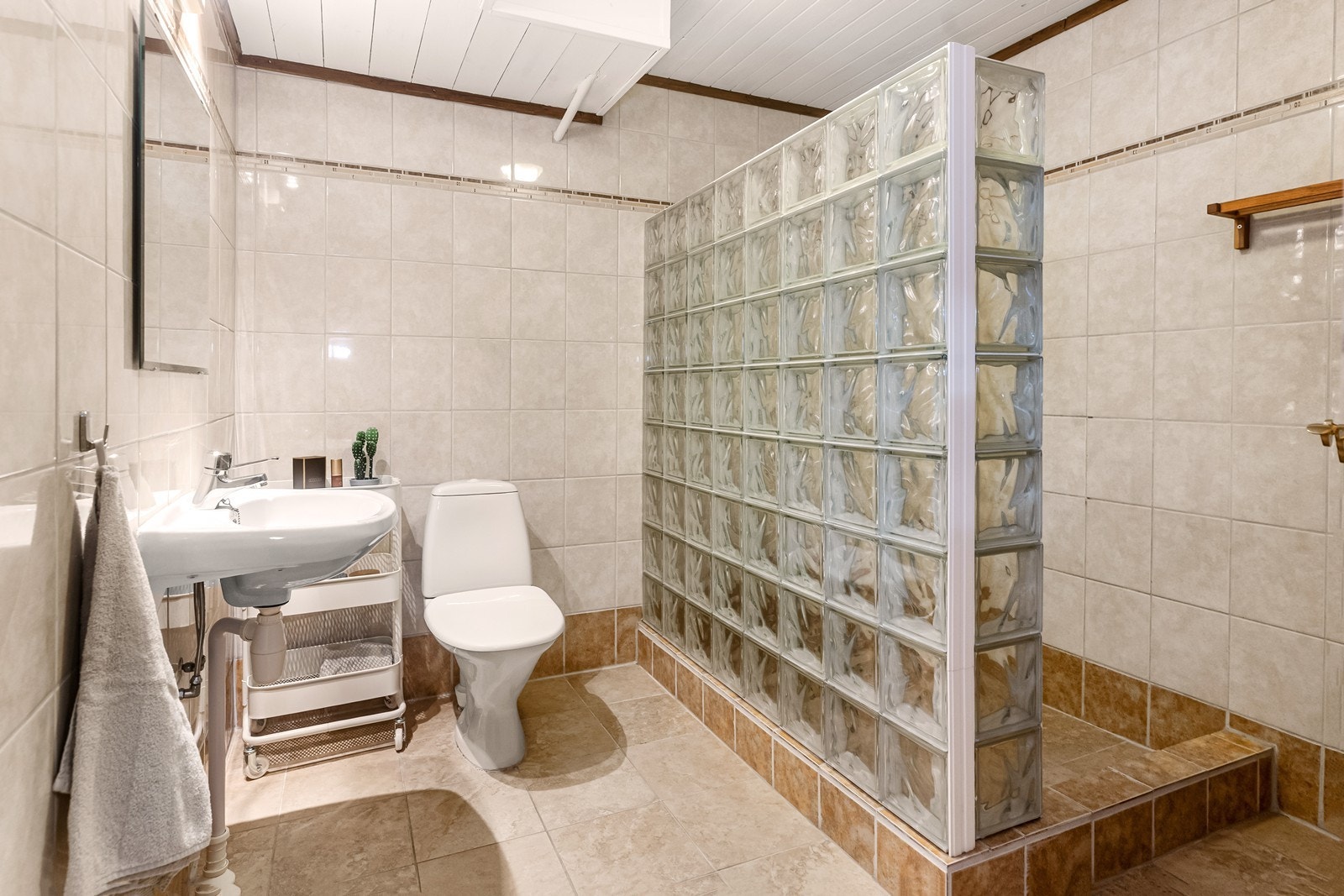 Badet i underetasjen er flislagt og utstyrt med dusjnisje, toalett og servant. Galleribilde