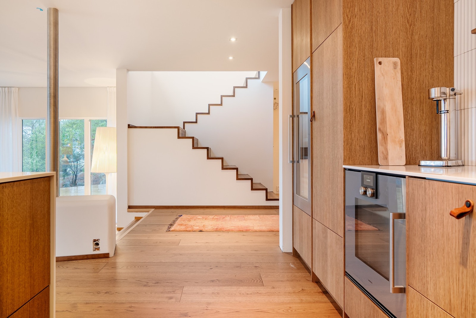 Fra kjøkkenet mot det ikonsike trappeløpet opp til andre etasje - et skulpturelt element i interiøret. Galleribilde