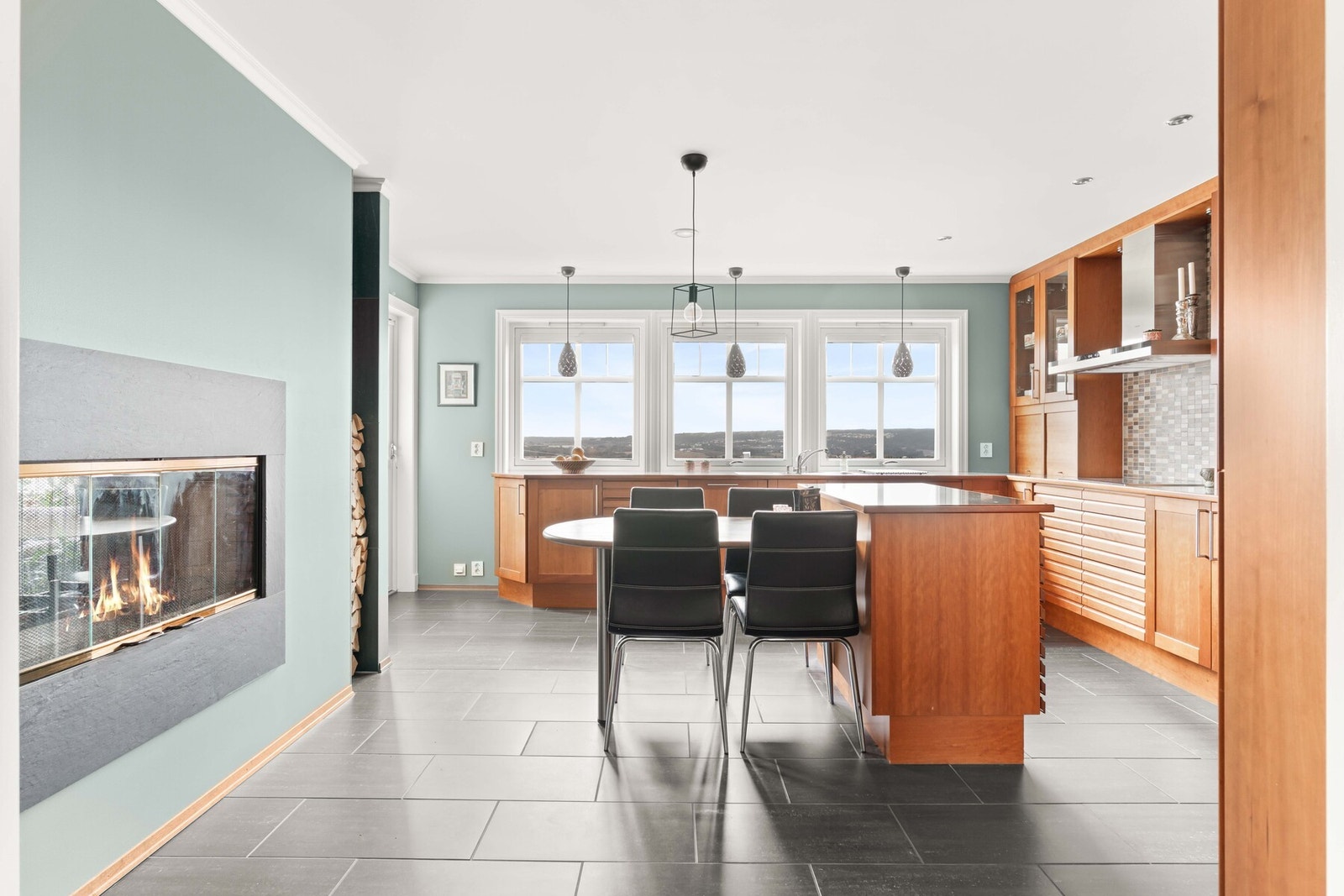 Som samlingssted har boligen et stort kjøkken med sorte gulvfliser, godt lysinnslipp og vegger malt i en delikat grønnfarge. Galleribilde