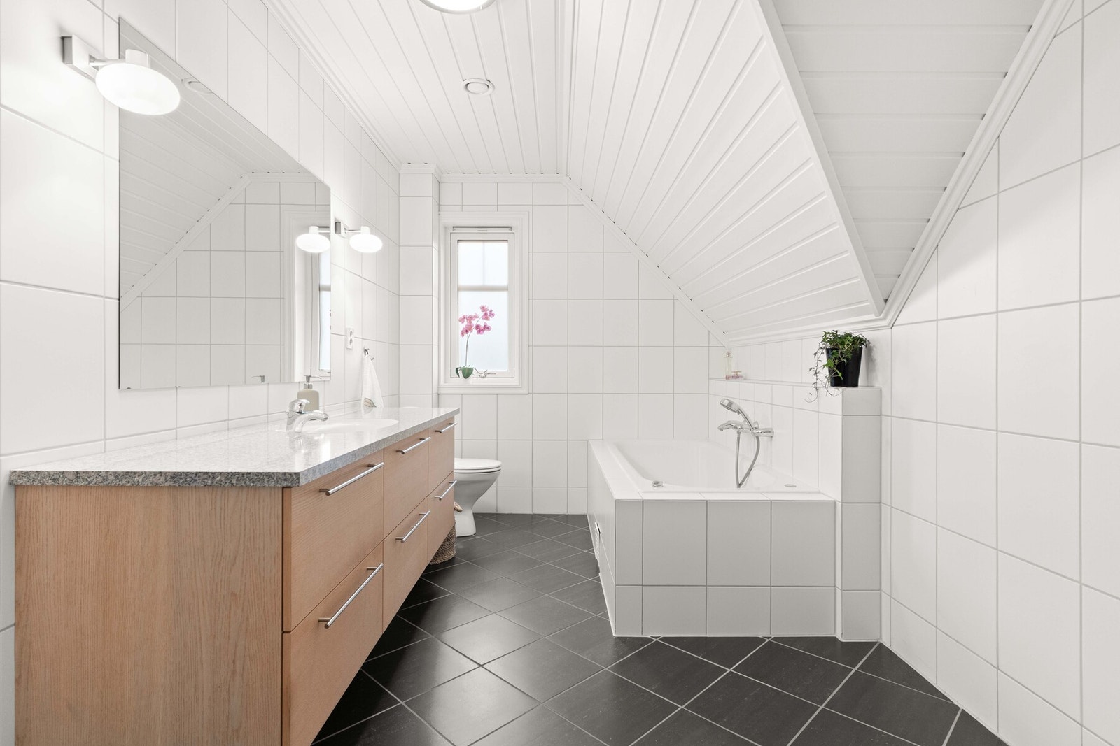 Planløsningen er praktisk, med stilrene bad i alle etasjer. På det øverste badet er det både et innfliset badekar og et dusjhjørne med skyvedør. Galleribilde