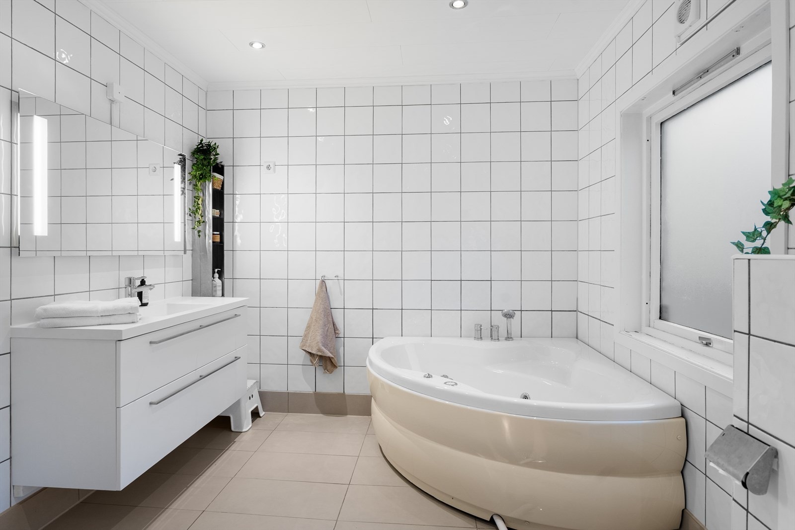 Romslig bad med fliser på gulv og vegger samt varmekabler i gulvet Galleribilde