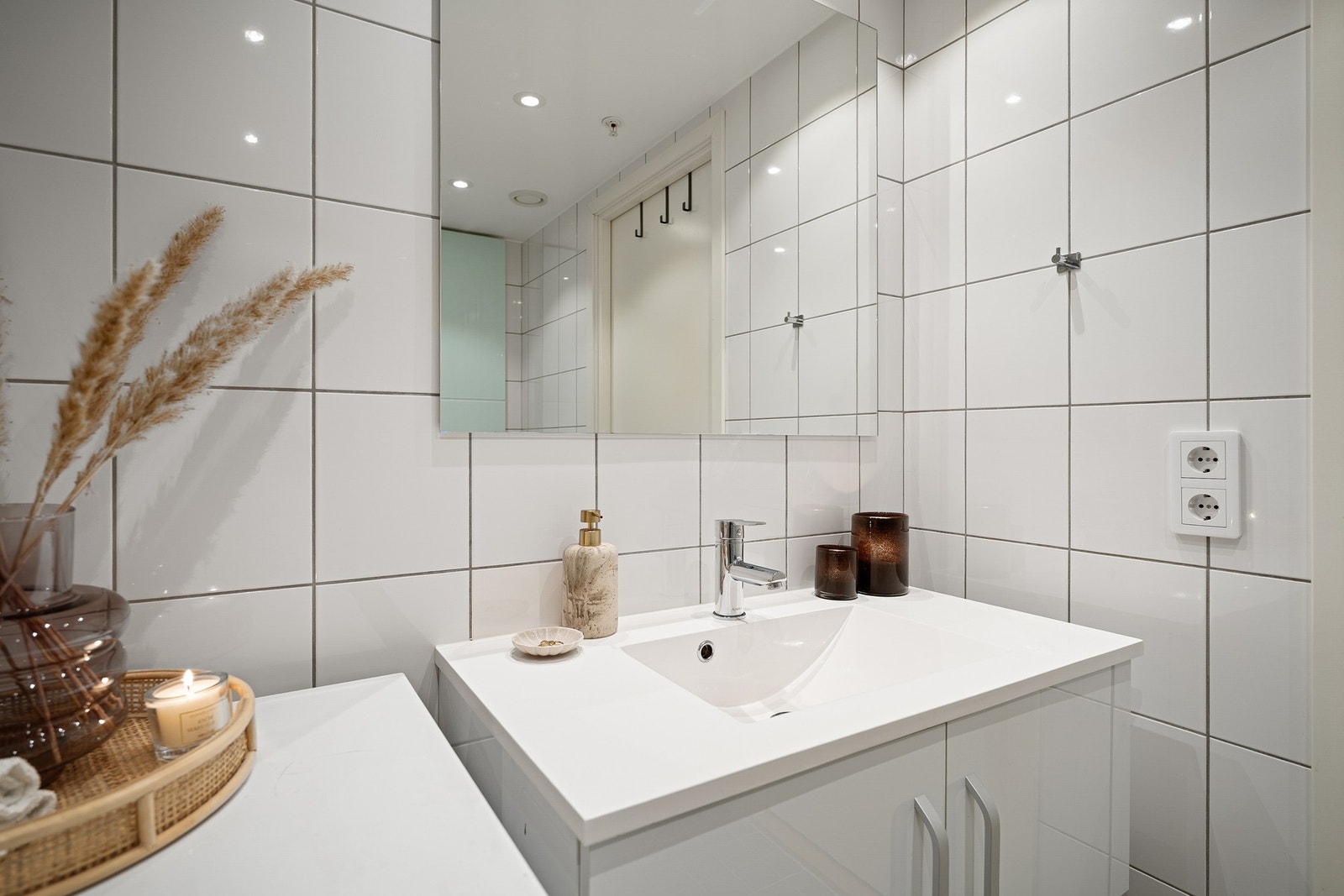 Veggmontert servantinnredning med glatte fronter og helstøpt servantplate med 1-greps blandebatteri. Veggmontert speil. Galleribilde