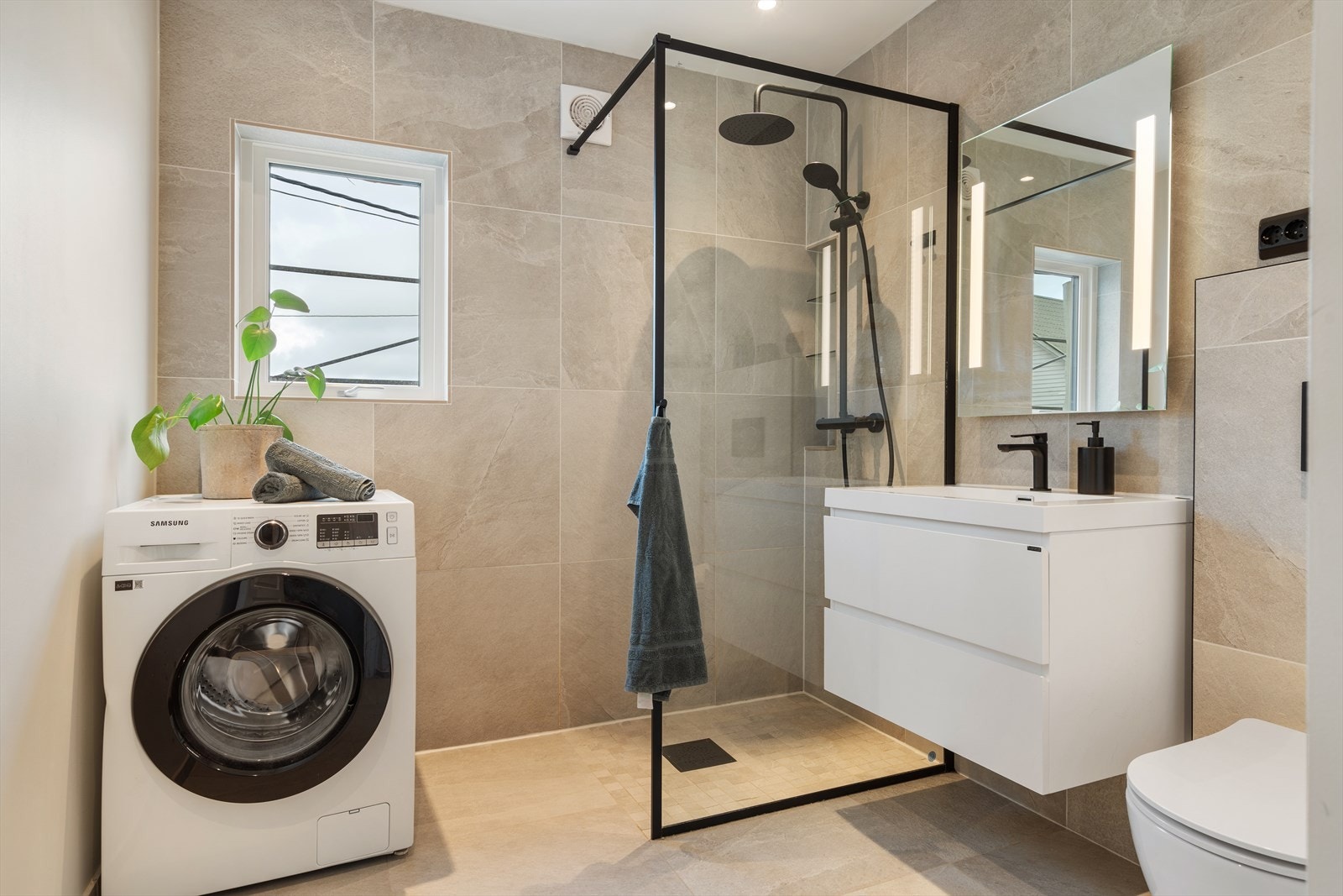 Helfliset baderom med varme i gulv. Flott baderomsinnredning med skuffer, samt speil med lys, i tillegg til dusjnisje og vegghengt toalett. Galleribilde