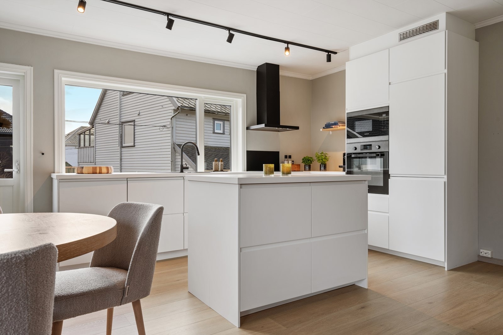 Moderne kjøkkeninnredning som glir pent inn som et møblement i stuen. Galleribilde