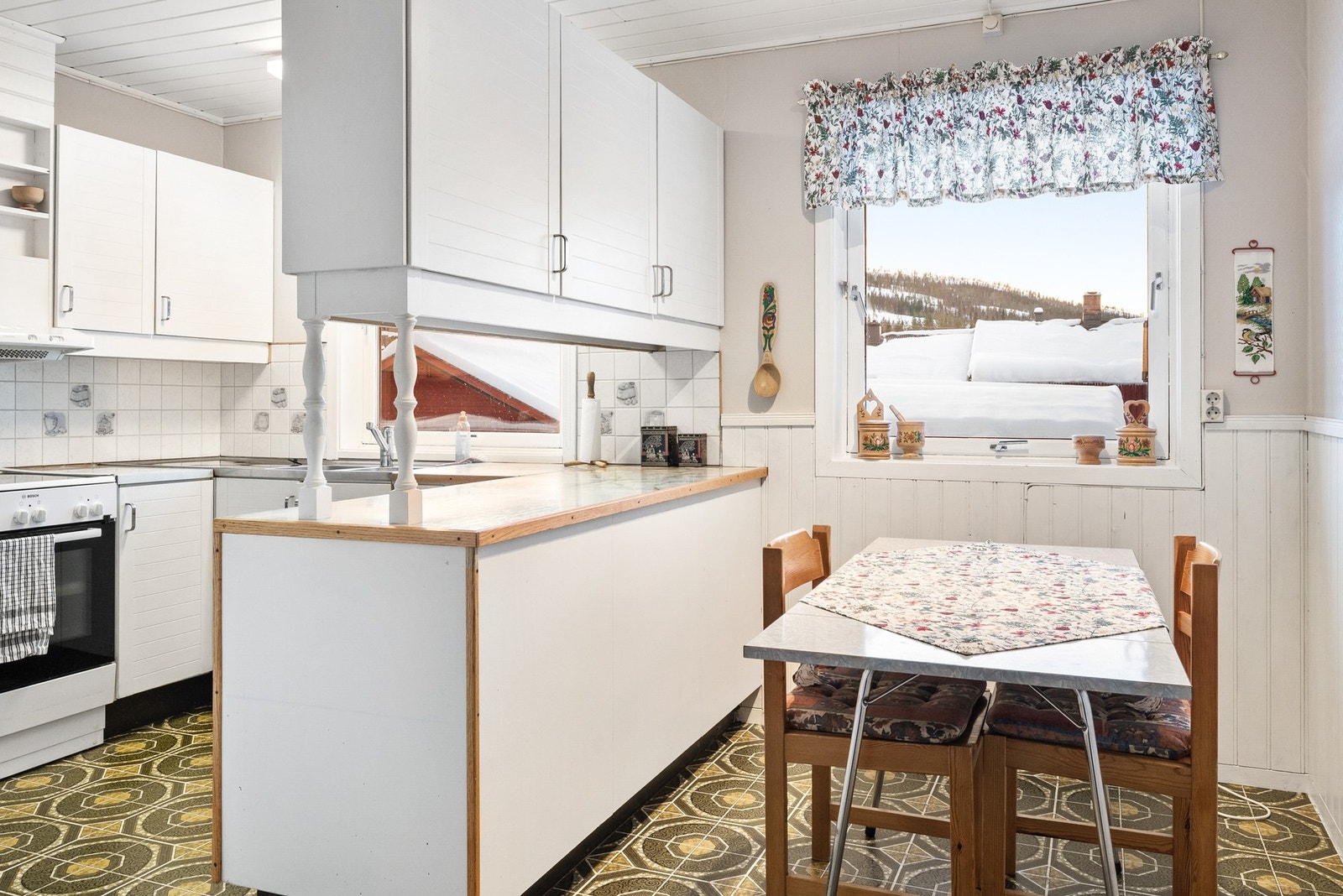 Kjøkkenet har innredning med profilerte fronter og benkeplate av laminat Galleribilde