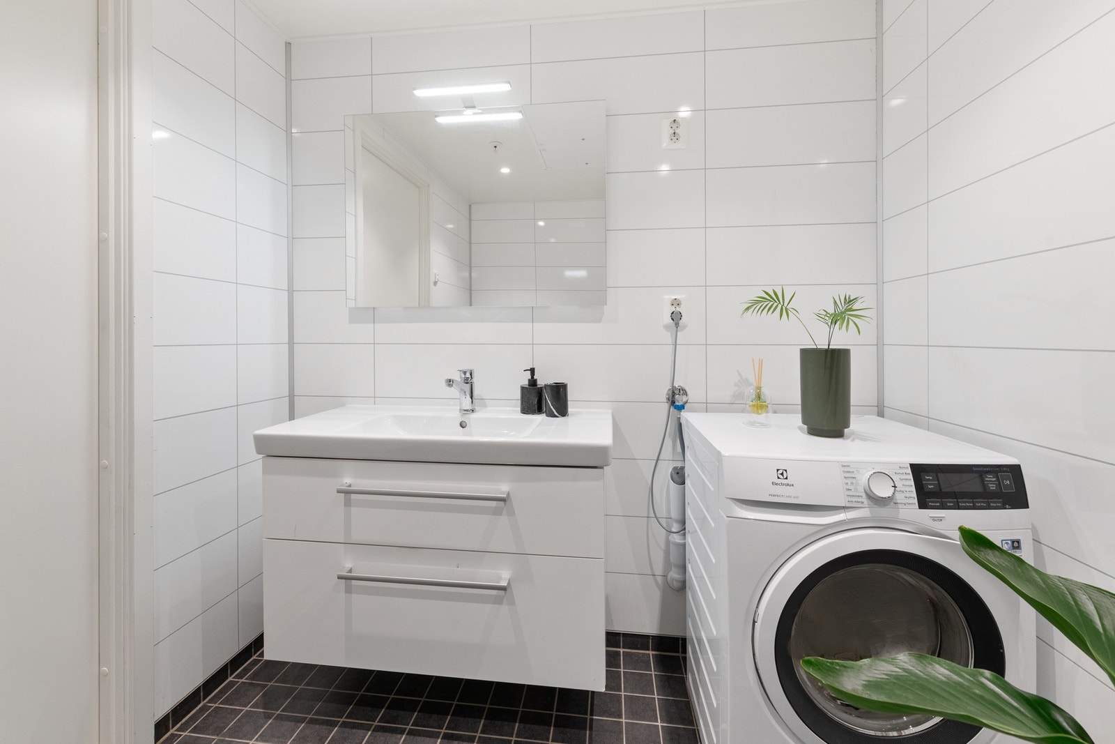 Hvit glatt baderomsinnredning med to skuffer. Heldekkende vask.Speil med lys over vask. Galleribilde