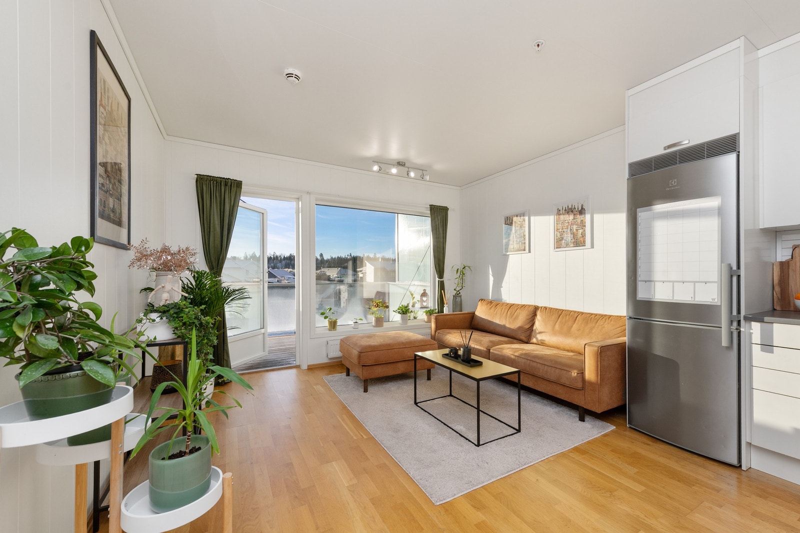 Romslig stue som ligger i åpen løsning med kjøkkenet Galleribilde