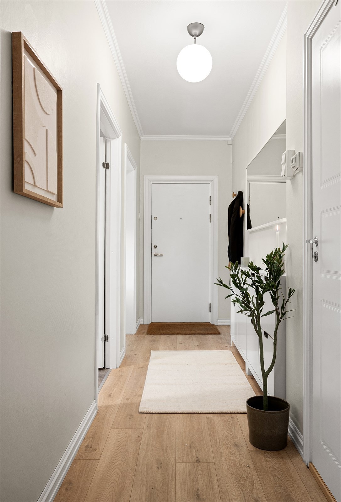 Velkommen inn i en romslig entré som fungerer som leilighetens fordelingspunkt. Galleribilde