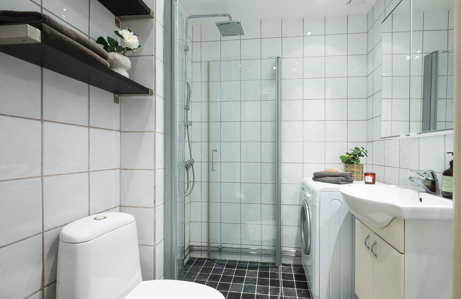 Funksjonelt bad med flislagt gulv og vegger, samt opplegg for vaskemaskin. Galleribilde