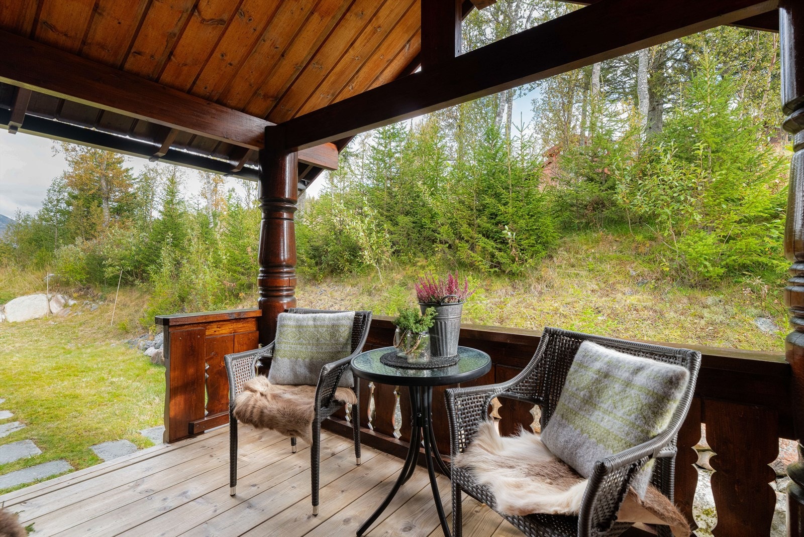 Fra innkjørselen er det lagt fine steinheller på grunn frem til inngang. Inngangspartiet har takoverbygg mot nordøst hvor det er fin plass til et lite møblement, beplantning og annet. Galleribilde