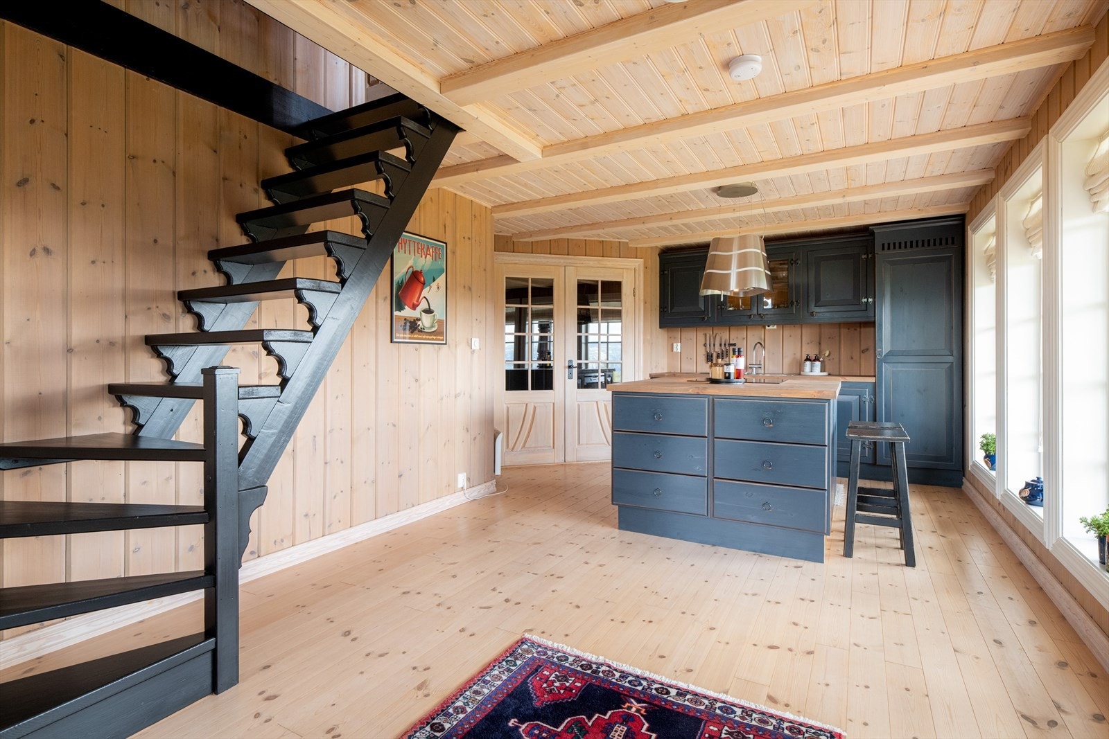 Sentralt mellom stue og kjøkken er det også trapp opp til loftetasjen. Det er montert rekkverk og håndløper på trapp opp til loft i etterkant av fotografering og takst. Galleribilde
