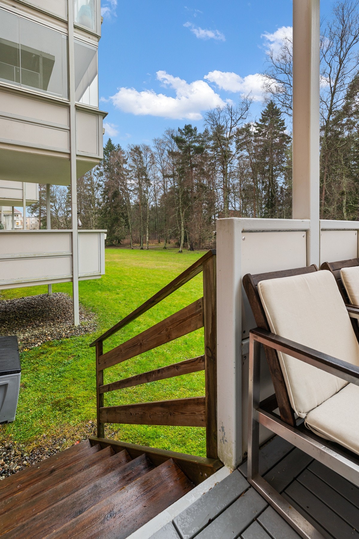 Løsningen gir en fin kombinasjon av uteplass på balkong, og enkel tilgang til uteområder. Utenfor sees plen, trær og beplantning som gir et åpent og naturnært preg. Galleribilde