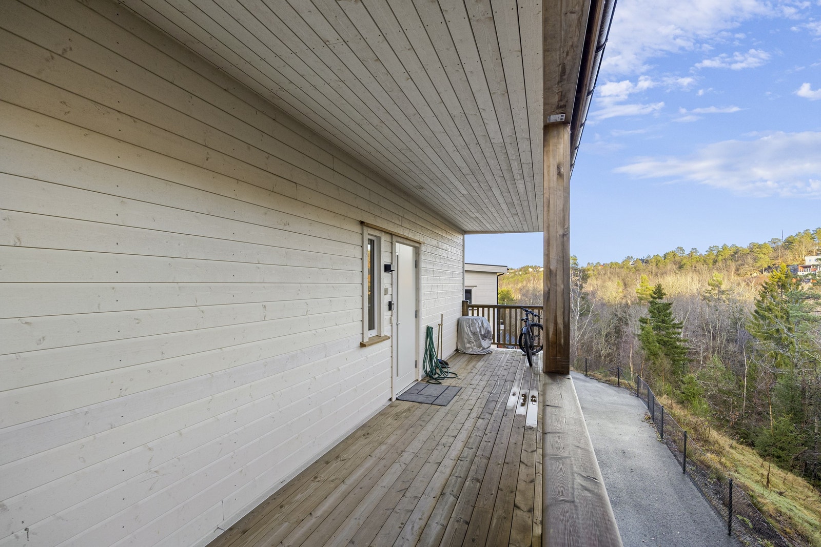 Inngangsparti med takoverbygg, perfekt ved regnværsdager eller for lettere å holde unna snøen. Det er flott skog bak eiendommen. Galleribilde