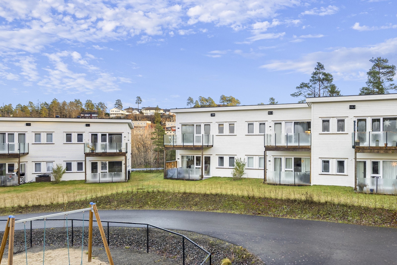 Godt opparbeidet og påkostet uteområde med beplantning, lekeplass og asfaltert snuhammer/parkeringsplass. Galleribilde