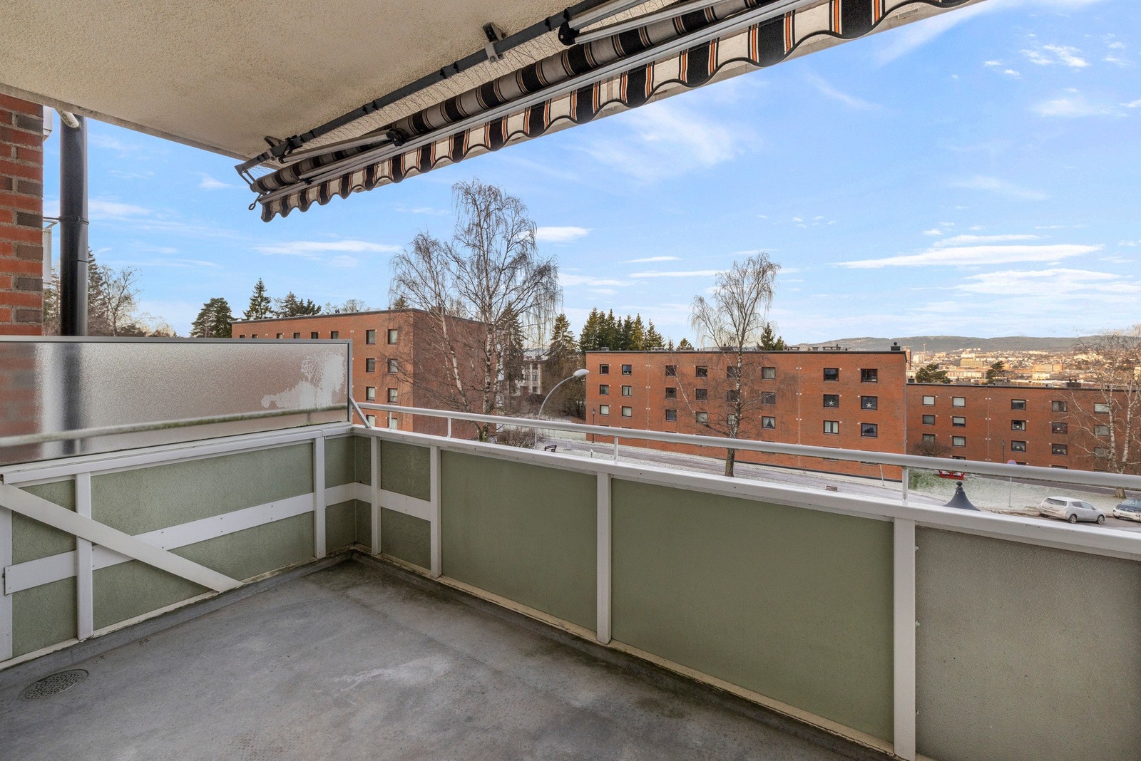 Balkongen har betongdekke, rekkverk i metall og markise Galleribilde