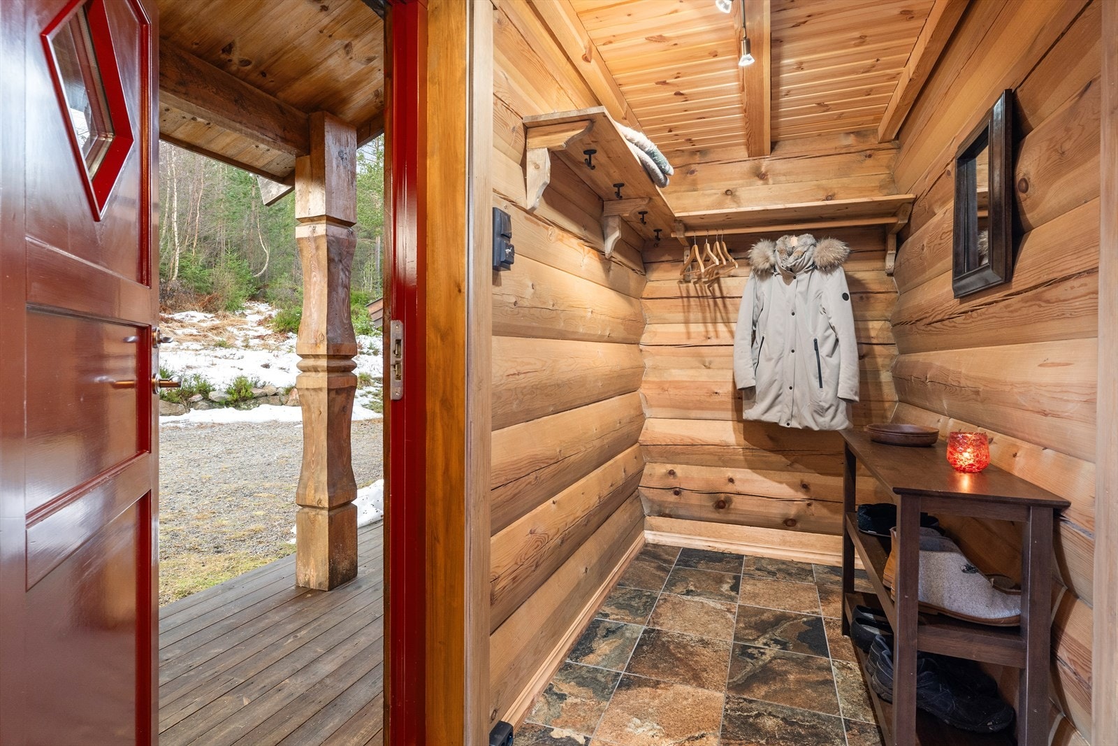 Med adkomst fra det hyggelige, overbygde inngangspartiet kommer man inn i hyttas gangarealer hvor det er god plass til sko- og ytterklær på fastmontert hylleløsning. Galleribilde