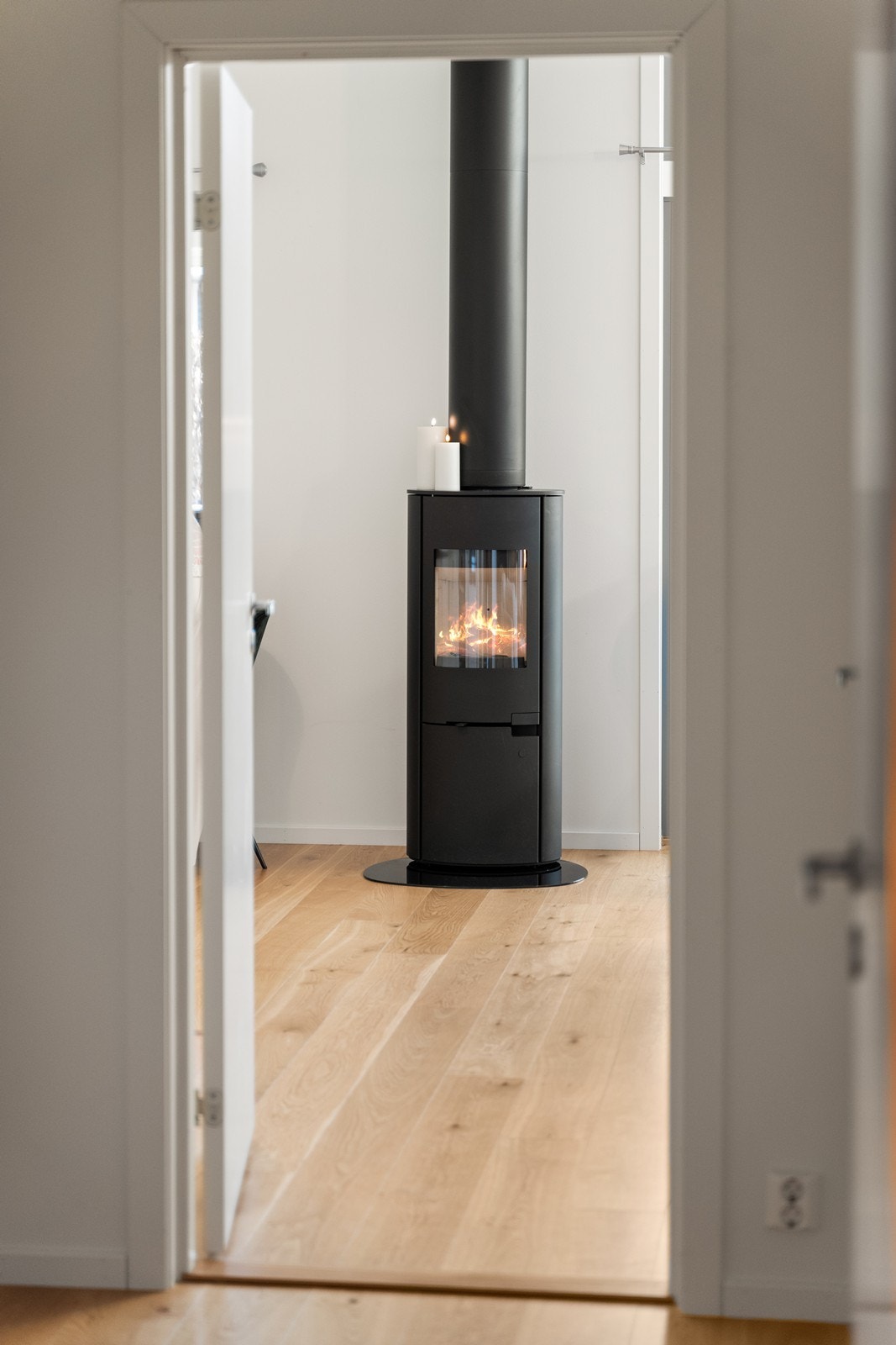 Fra gangen får man et glimt av den sosiale sonen med peisovnen sentralt plassert. Galleribilde