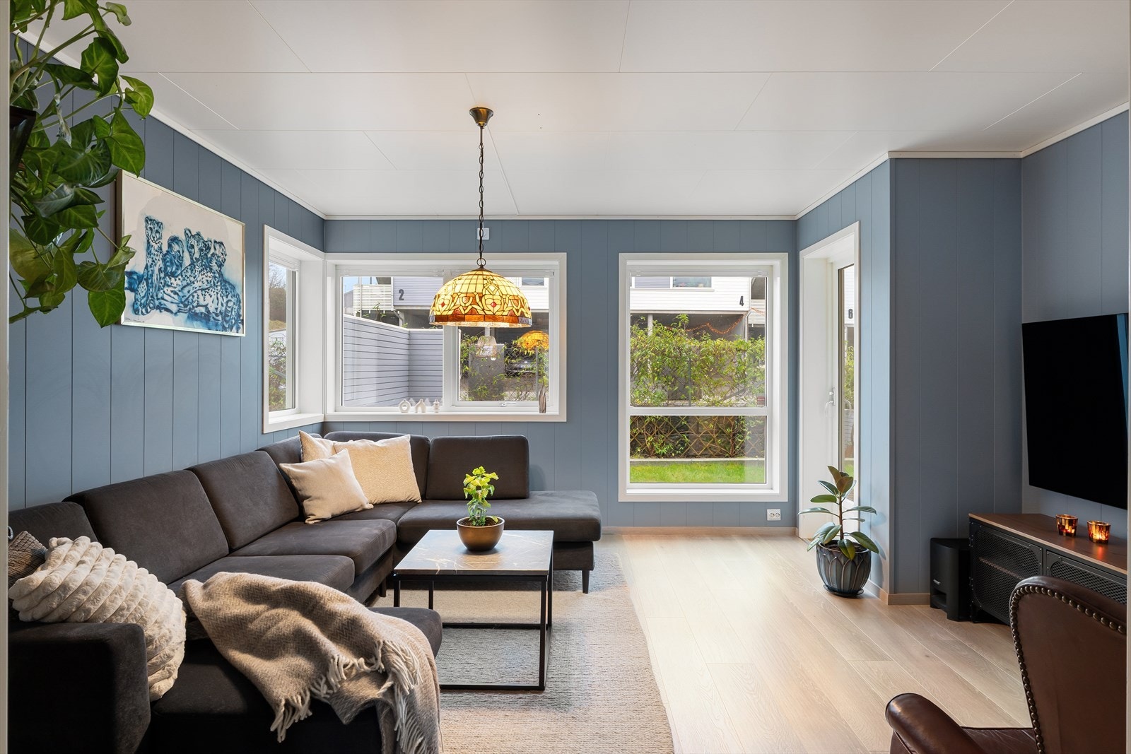 Det er utgang til terrasse og hage fra stuen Galleribilde