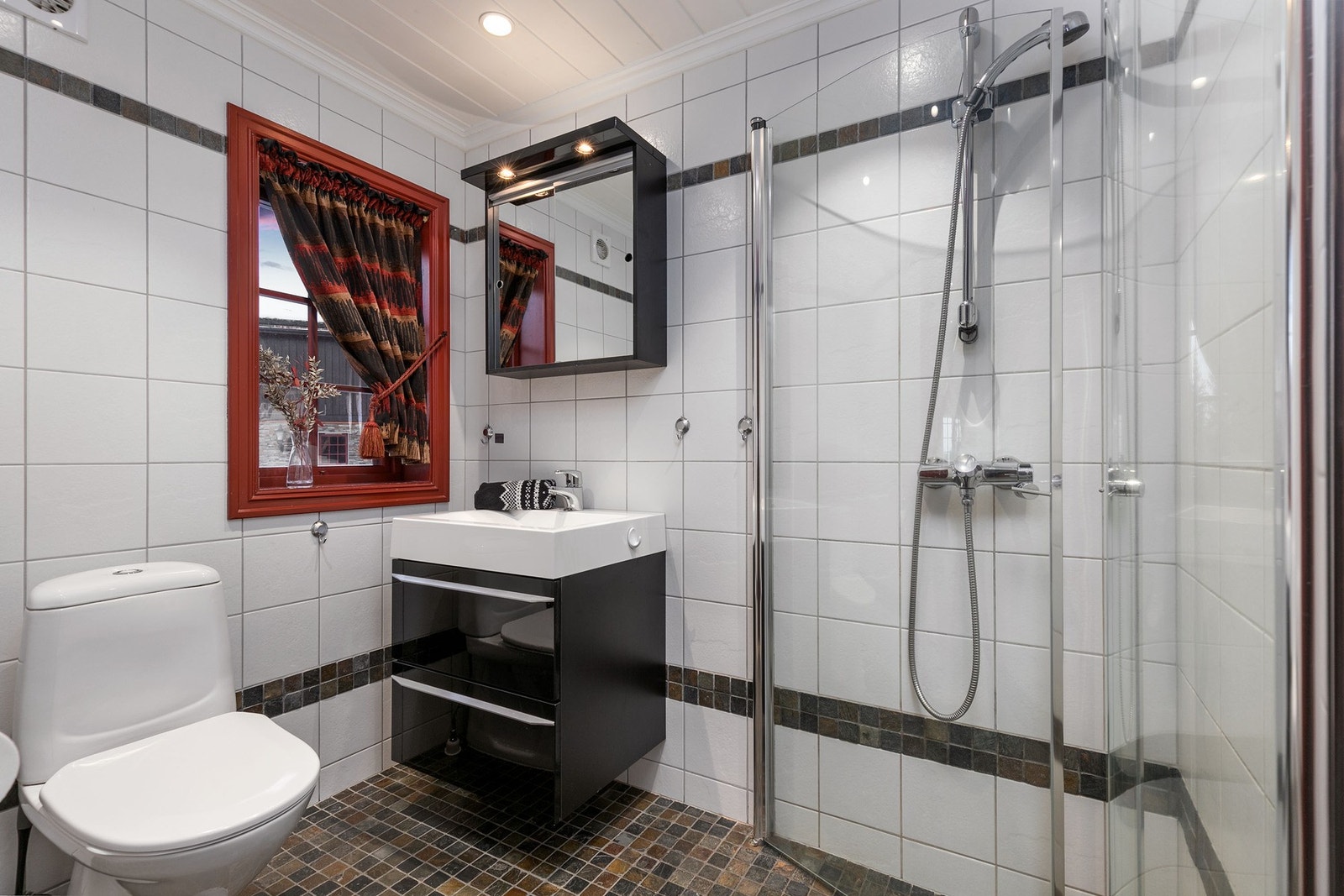 Bad 2 befinner seg i 1. etasje. Badet har flislagte overflater på gulv og vegger, samt panel i himling. Baderomsinnredning bestående av skuffer med servant. Galleribilde