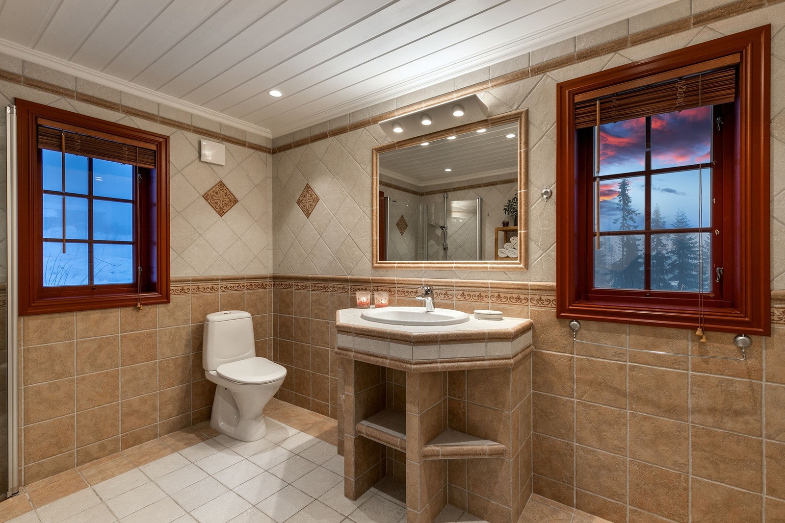 Badet har flislagte overflater på gulv og vegger, samt panel i himling. Baderomsinnredning bestående av innfliset servant. Galleribilde