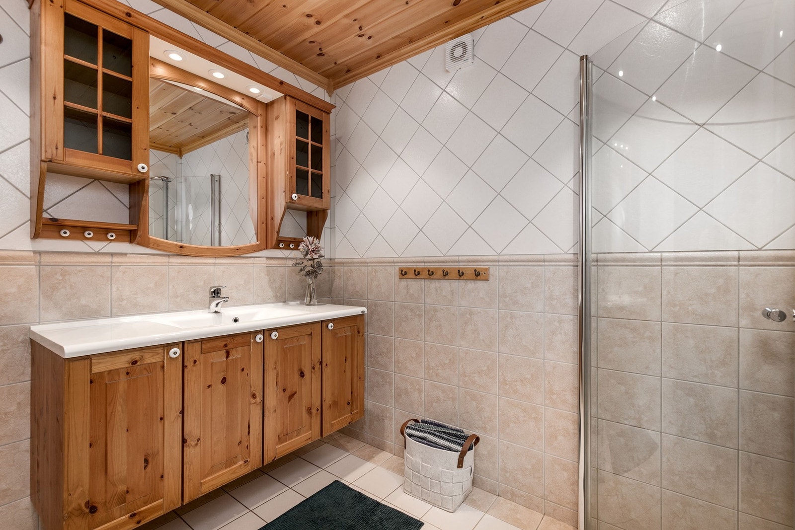 Bad 3 befinner seg i U. etasje. Badet har flislagte overflater på gulv og vegger, samt panel i himling. Baderomsinnredning bestående av skap med servant. Galleribilde