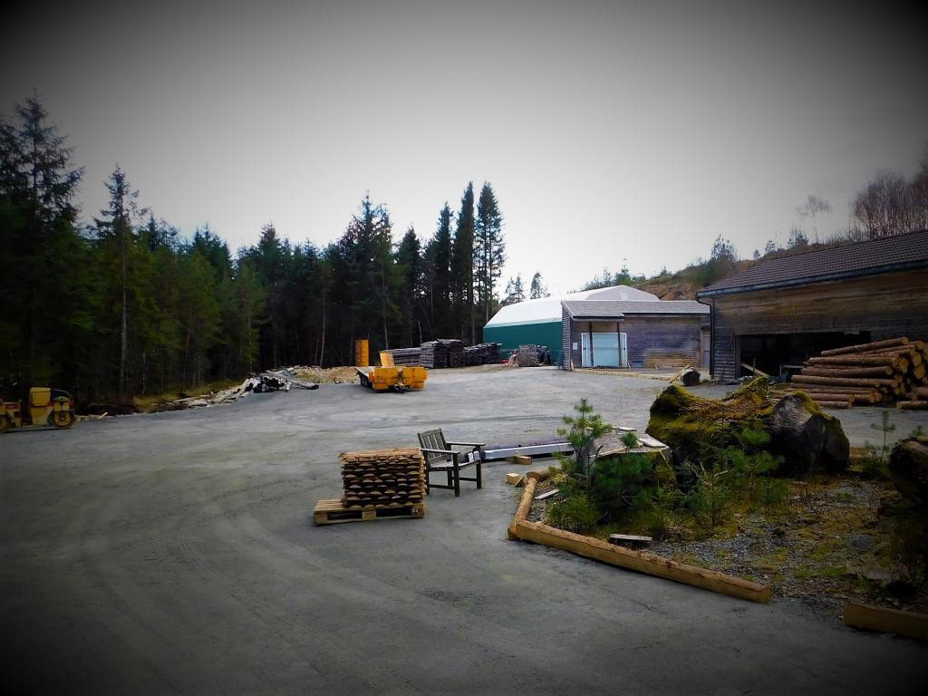 Sagbrukstomta med saghuset til høyre, produksjonshall /trevareverksted til venstre og materiallager i mellom. Galleribilde