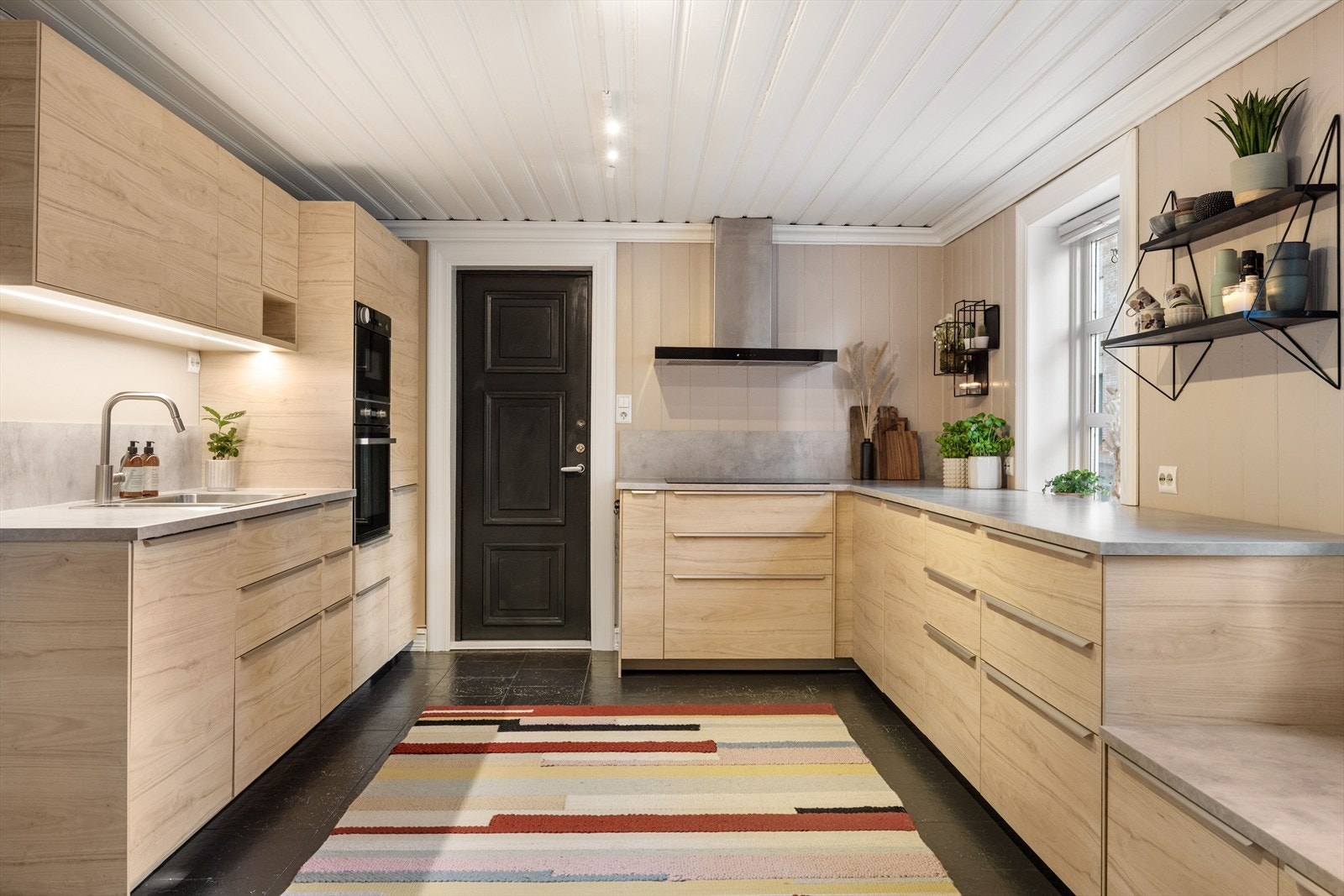 Det er egen inngang til kjøkkenet fra bakgården, praktisk om man har handlet mye. Galleribilde