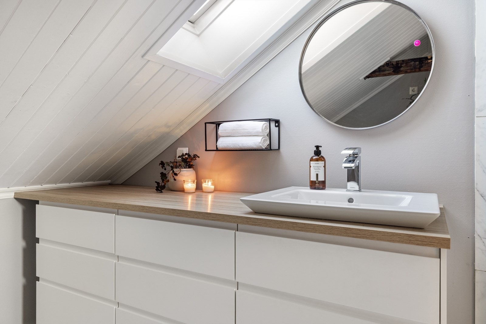 Romslig baderomsinnredning med skuffer og benkeplate med nedfelt servant. Det er el-uttak over innredningen. Galleribilde