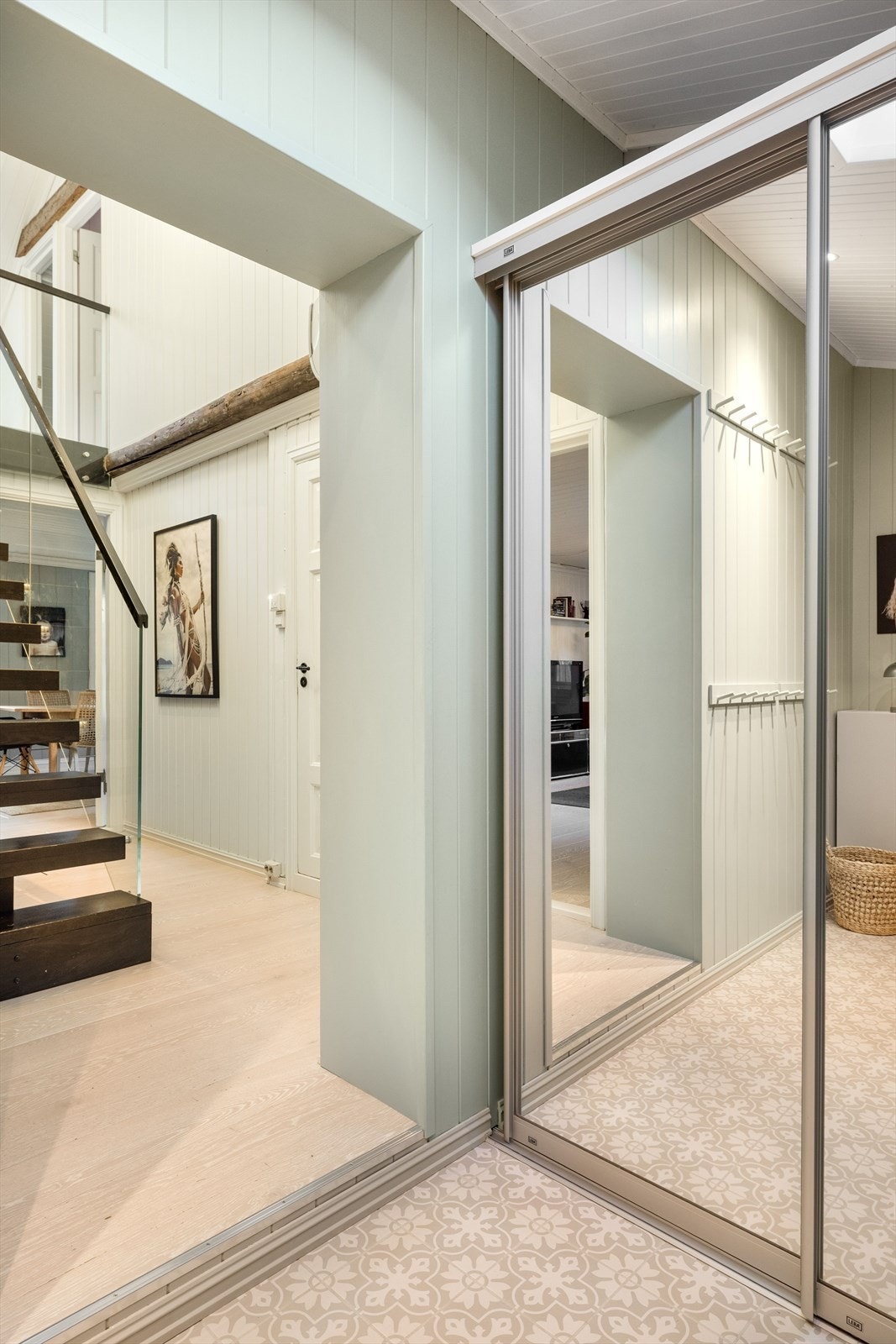 På gulvet i entréen er det lagt flotte fliser med historisk motiv som passer godt til boligen. Det er satt inn en skyvedørsgarderobe for plass til sko og yttertøy. Det er også plass til øvrig oppbevaring. Galleribilde