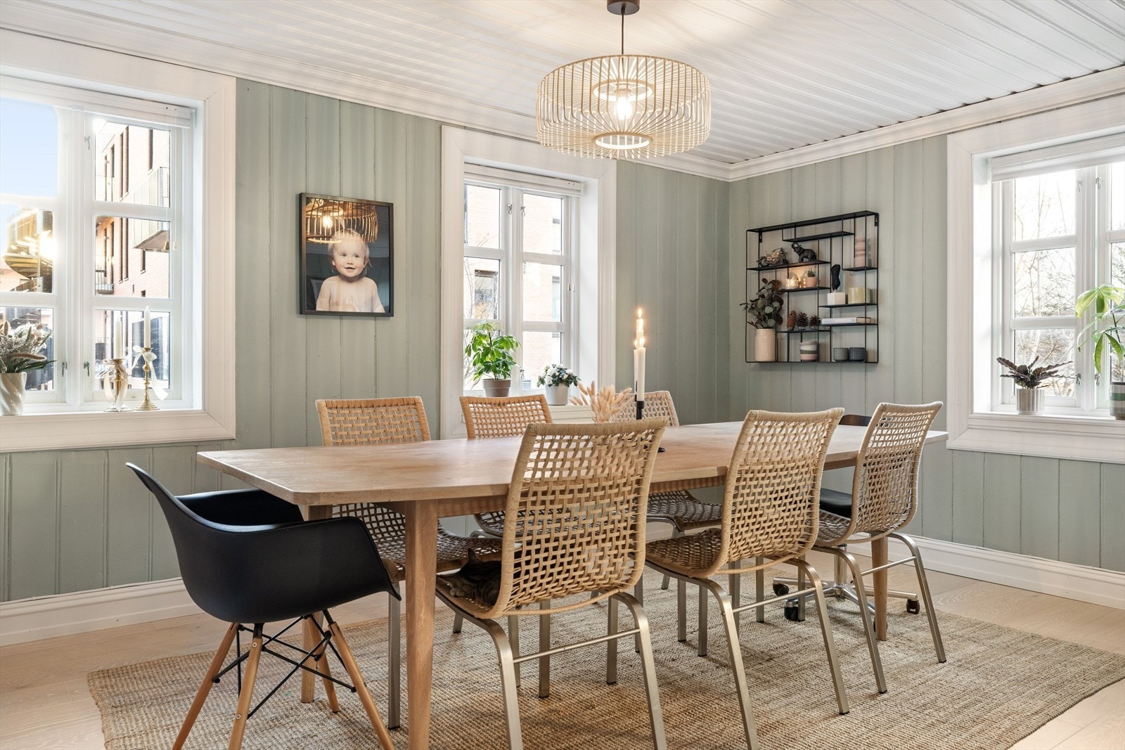 Her får du en lun og hyggelig spisestue som er malt i en dus og delikat grønntone. Vegger og himling er kledd med panel, mens på gulvet er det heltre. Galleribilde