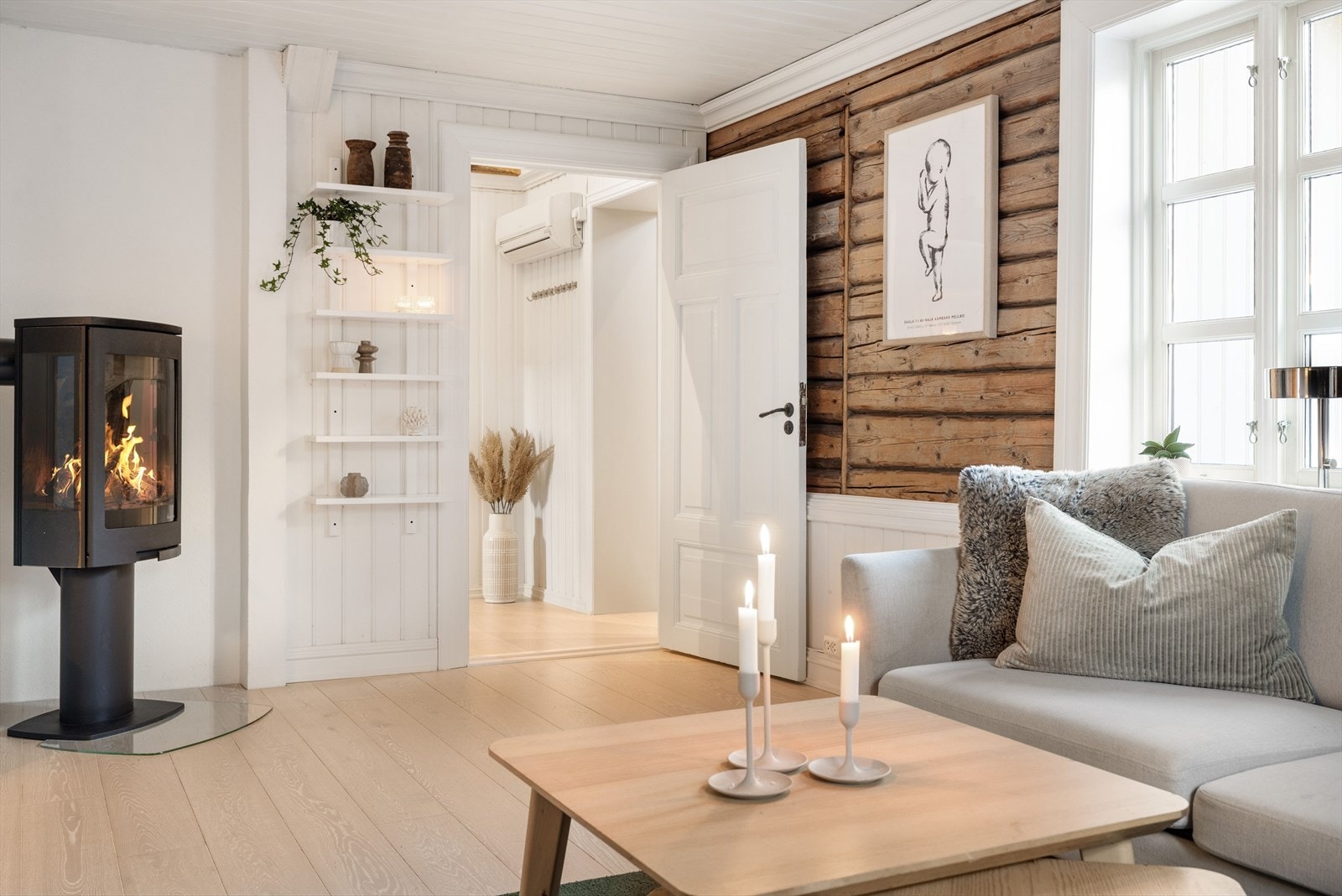 Tømmerveggene kombinert med brystning gir en lun følelse til rommet. I tillegg har du en mer moderne pesiovn som gir god varme på kalde dager. Galleribilde