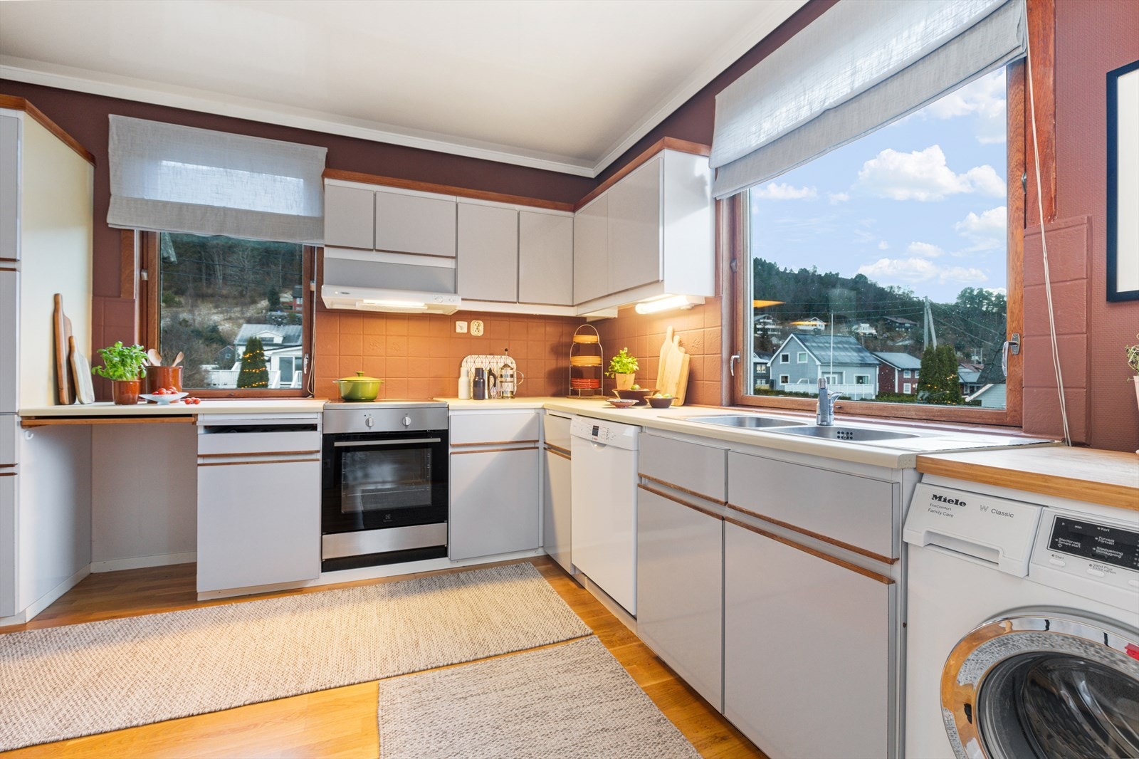 Kjøkken har kjøkkeninnredning med malte glatte skapfronter og benkeplater av laminat med nedfelt vask | innredningen har kjøkkenventilator med mekanisk avtrekk og utsparing for komfyr, oppvaskmaskin og vaskemaskin Galleribilde