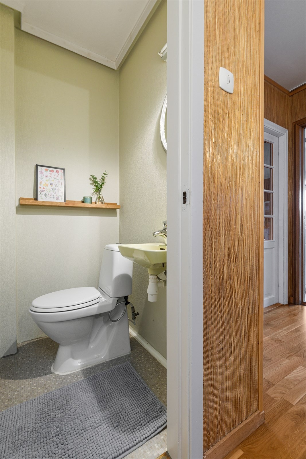 Toalettrom i hovedetasjen har vinylbelegg på gulv og er utstyrt med vegghengt vask og wc Galleribilde