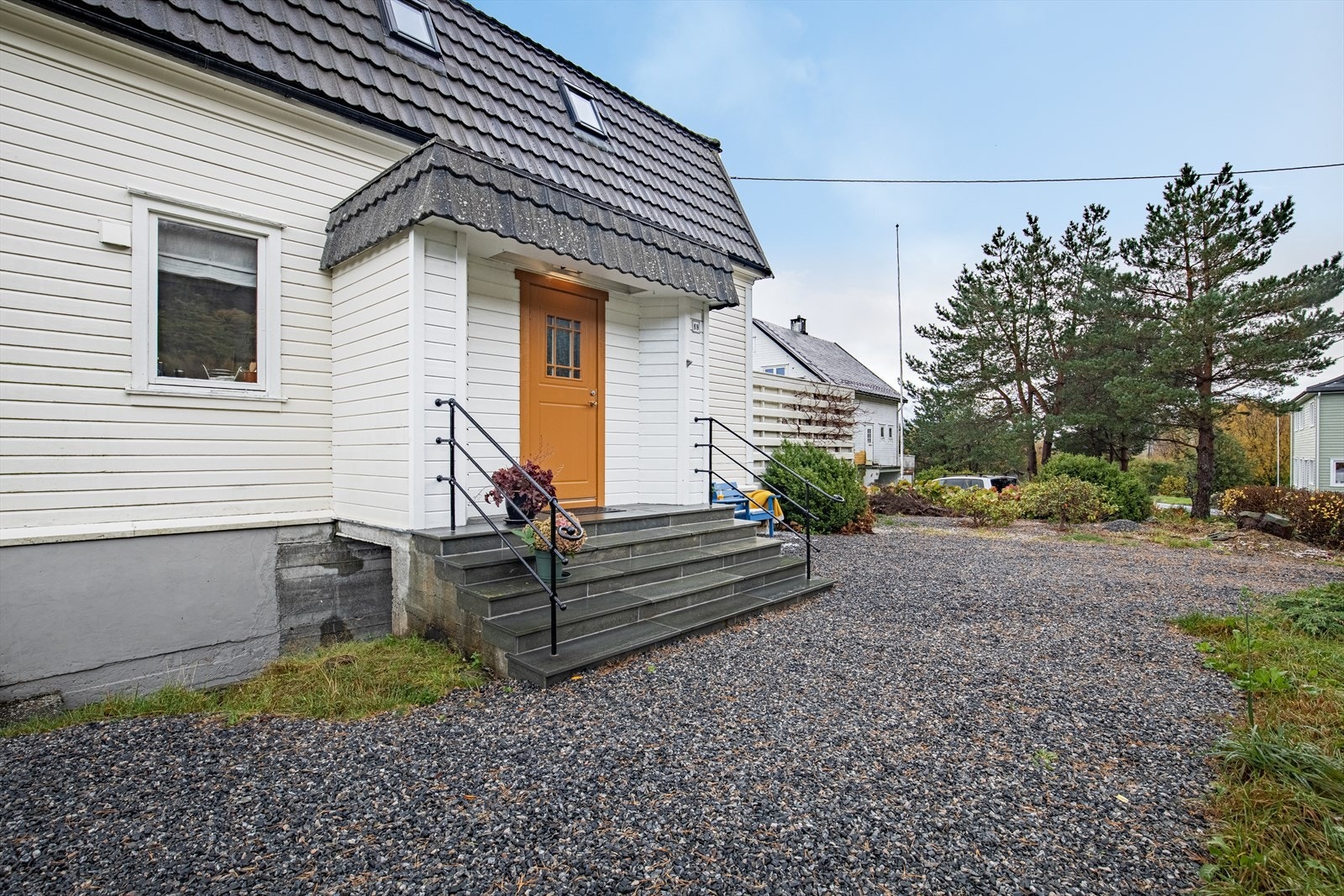 Fasade/innkjørsel | tomtens innkjørsel og parkeringsarealer har toppdekke av singel Galleribilde