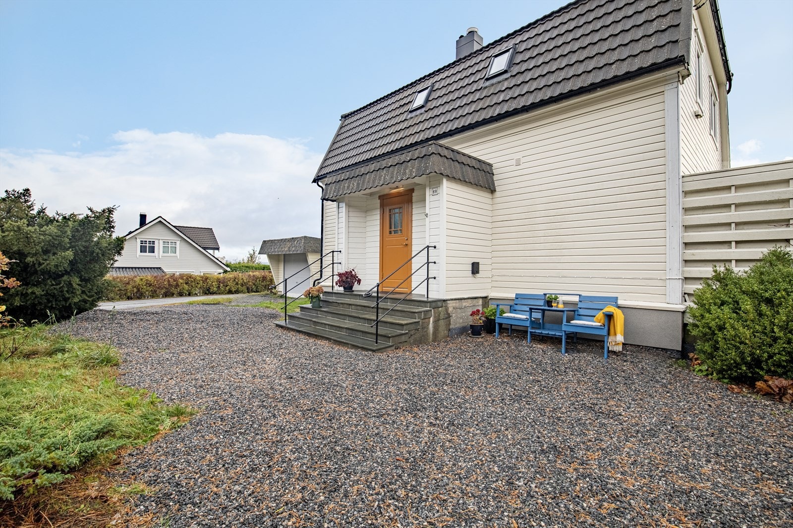 Fasade/innkjørsel | tomtens innkjørsel og parkeringsarealer har toppdekke av singel Galleribilde