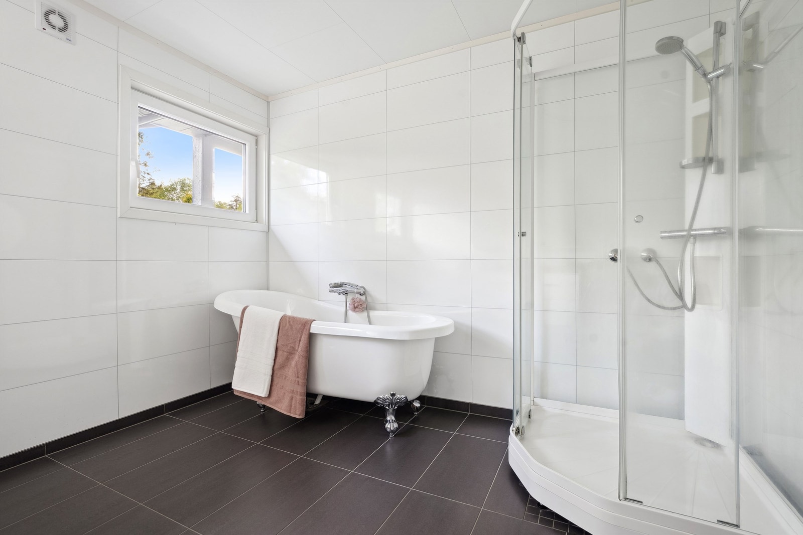 Badet er stort og inneholder både badekar og dusj Galleribilde