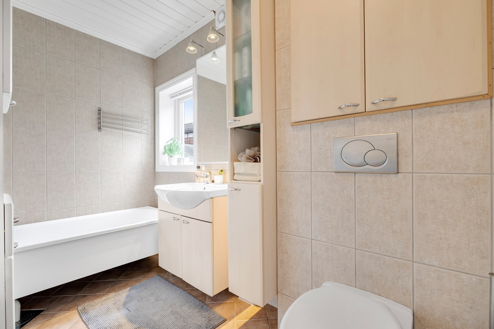 Hovedbadet er helfliset med moderne innredning og utstyrt med badekar. Galleribilde