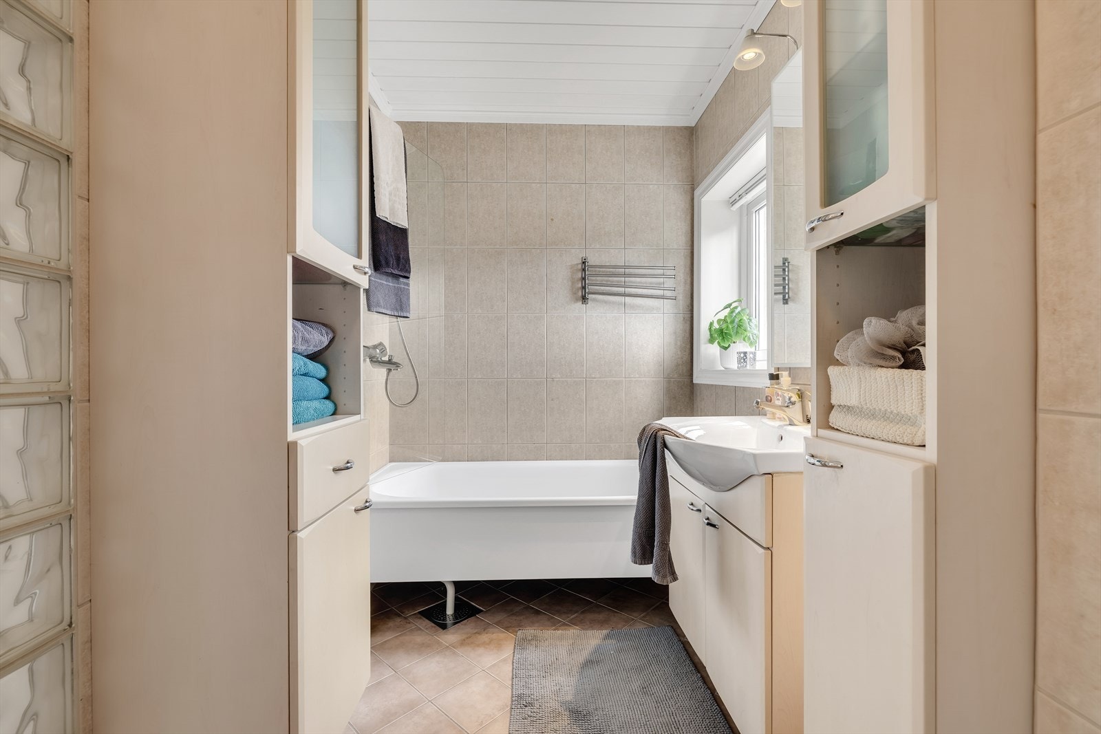 Badet er lyst og helfliset bad med varme i gulv. Galleribilde