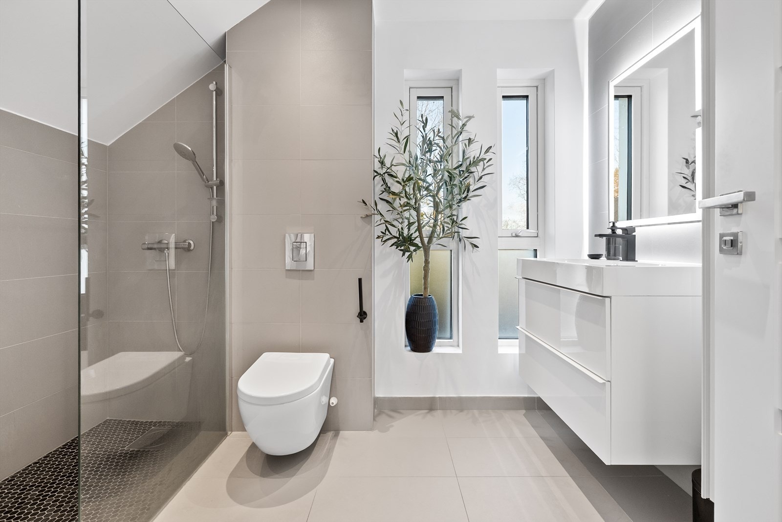 Badet i 2 etasje med fliser på gulv og vegg gir et stilrent uttrykk. Galleribilde