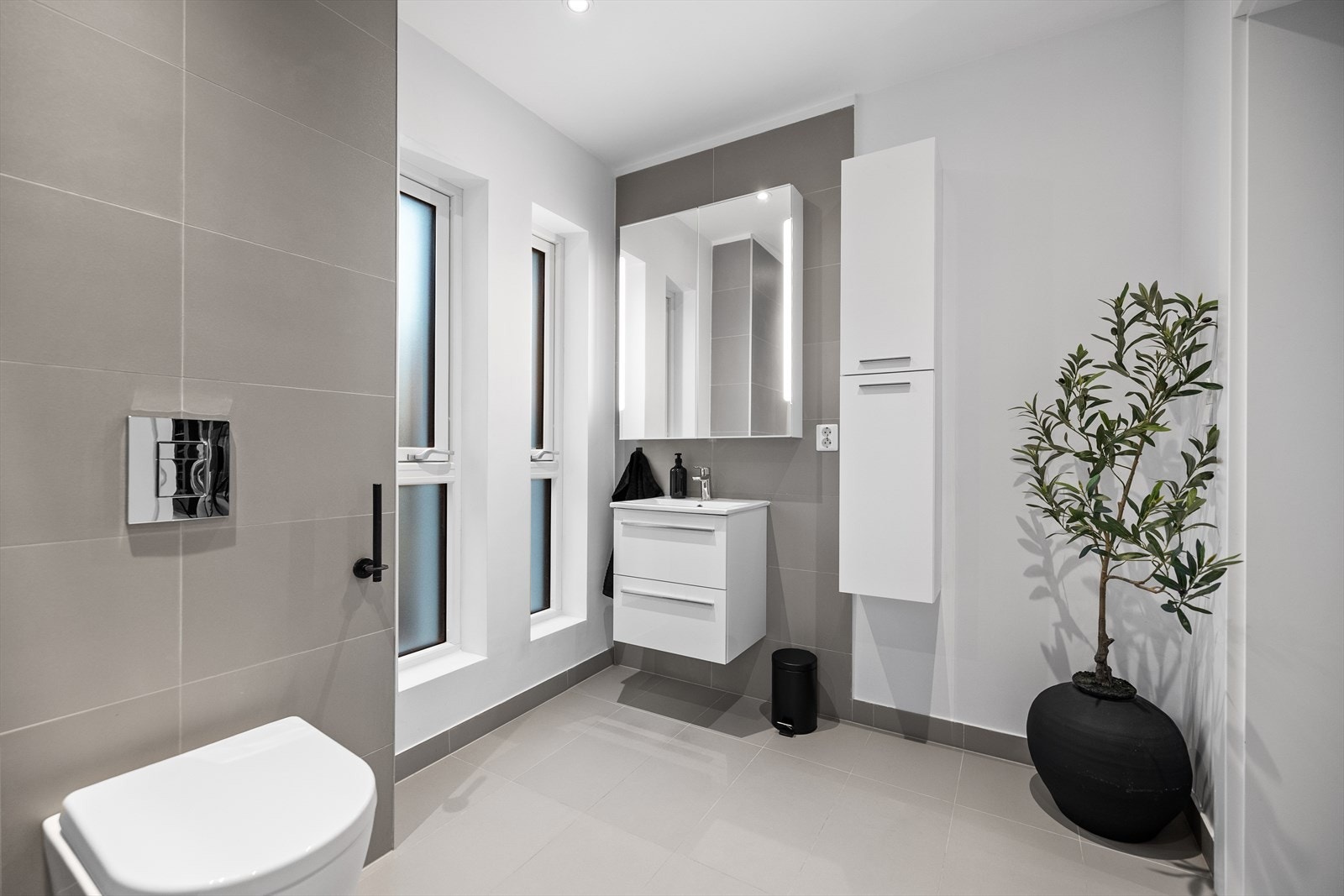 Badet i 1. etasje har fliser på gulv og vegger gir et moderne uttrykk, med mekanisk ventilasjon for et godt inneklima. Galleribilde